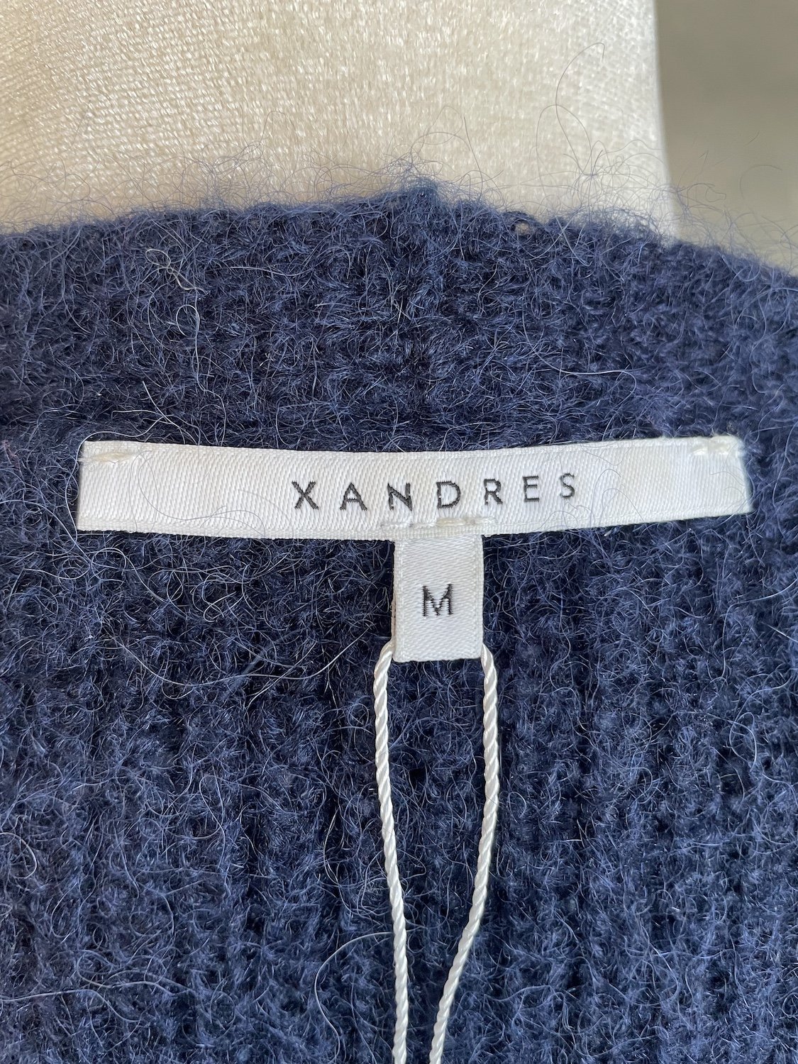 Close-up of the interior Xandres brand label and size M tag.