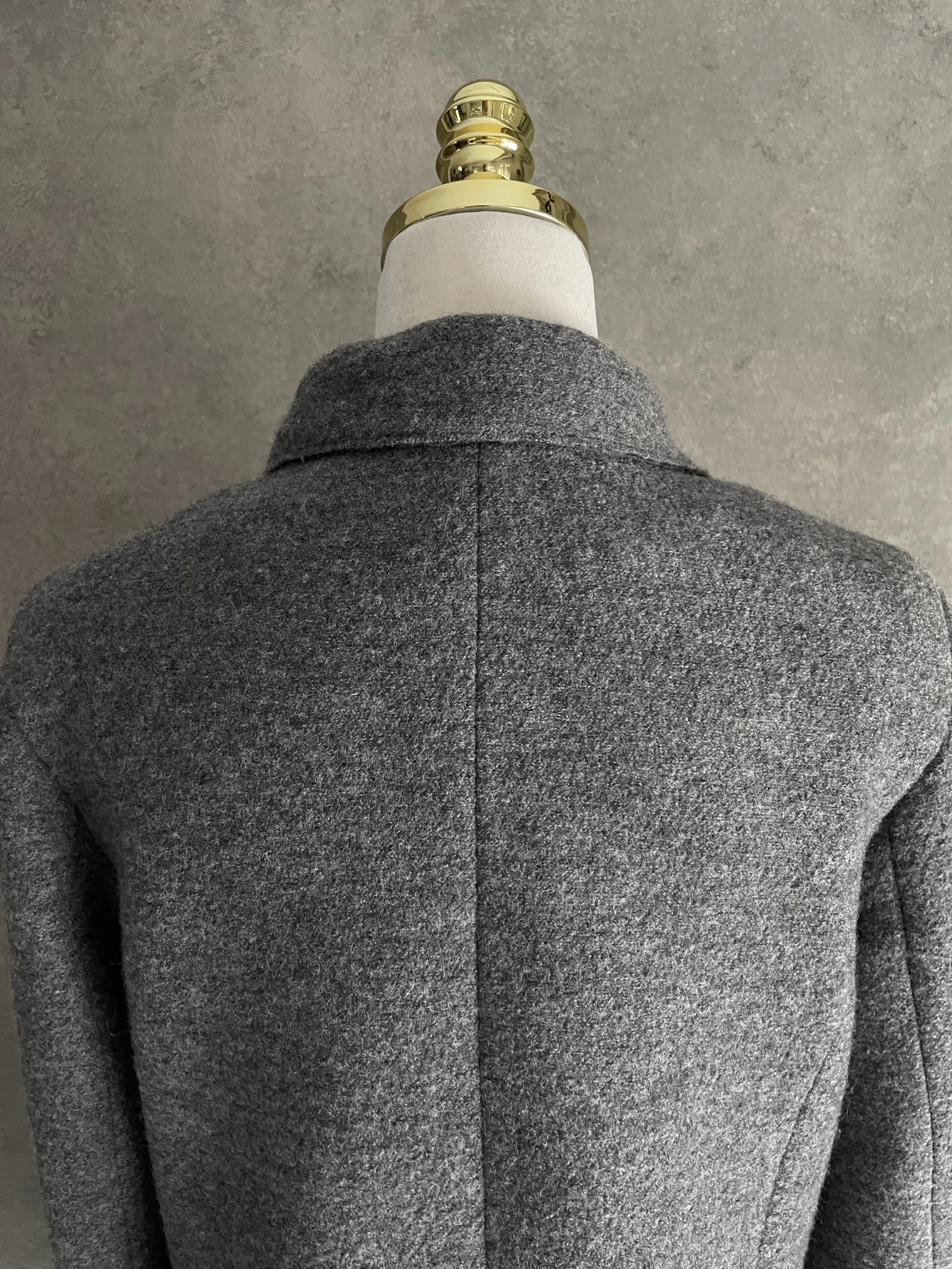 Close-up of the upper back and neck area of the grey wool coat, focusing on the collar detail and wool texture.