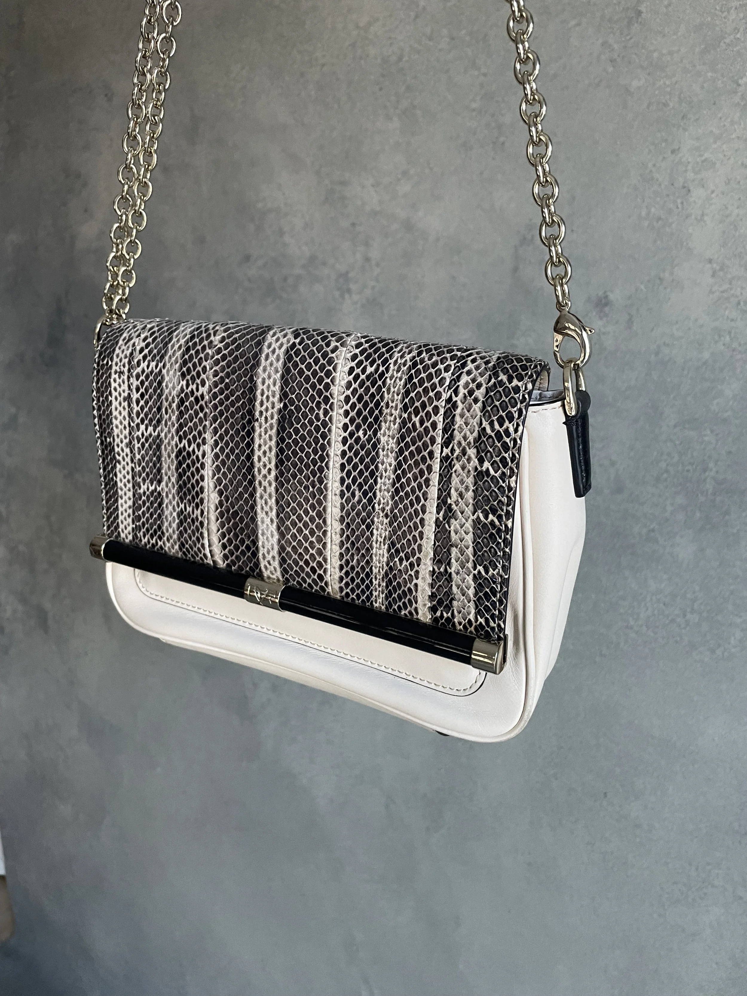 Side angle of the DVF 440 envelope bag, showcasing the elegant gold chain attachment and the structured silhouette.