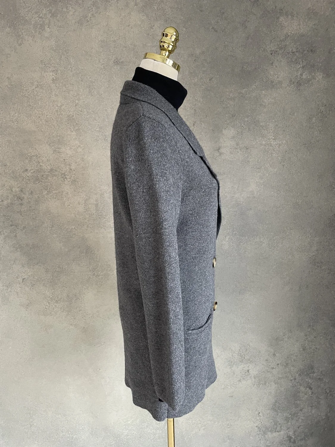 Three-quarter profile view of the grey cashmere coat cardigan on the mannequin.