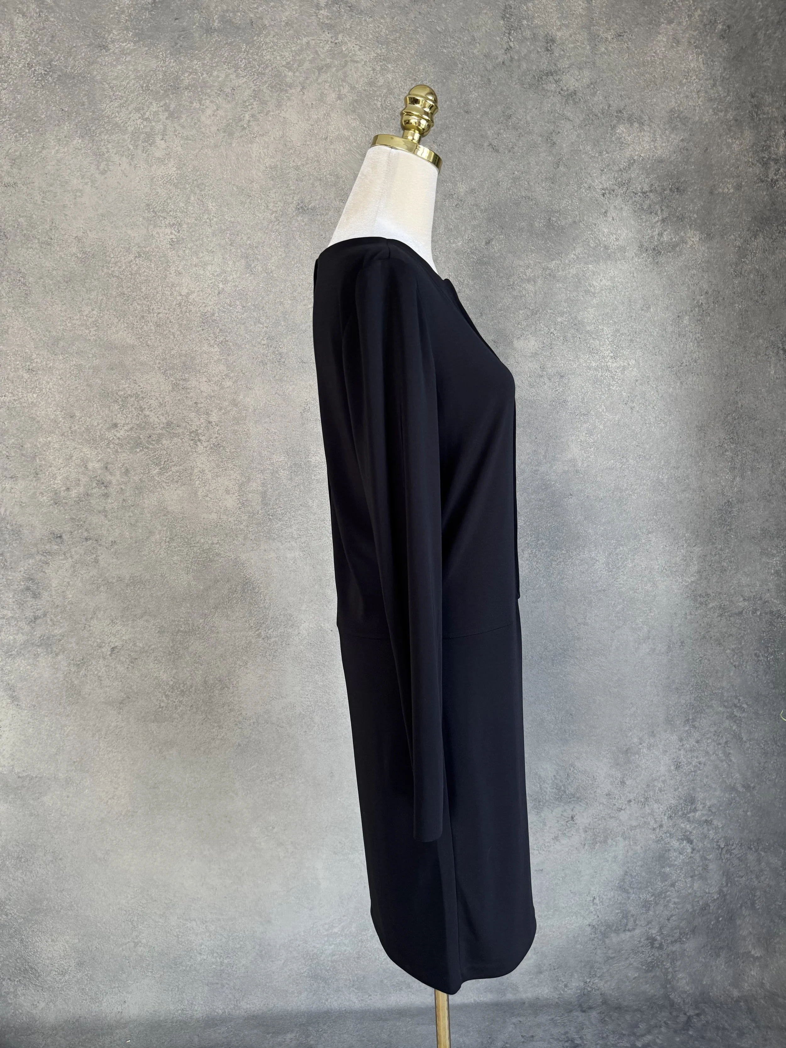 Side profile view of the black Filippa K dress on a mannequin, showing the clean lines and long sleeves.