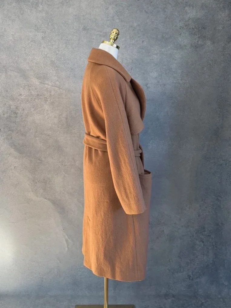 Side profile view of the camel brown wrap coat, showing the tailored sleeve and belt.