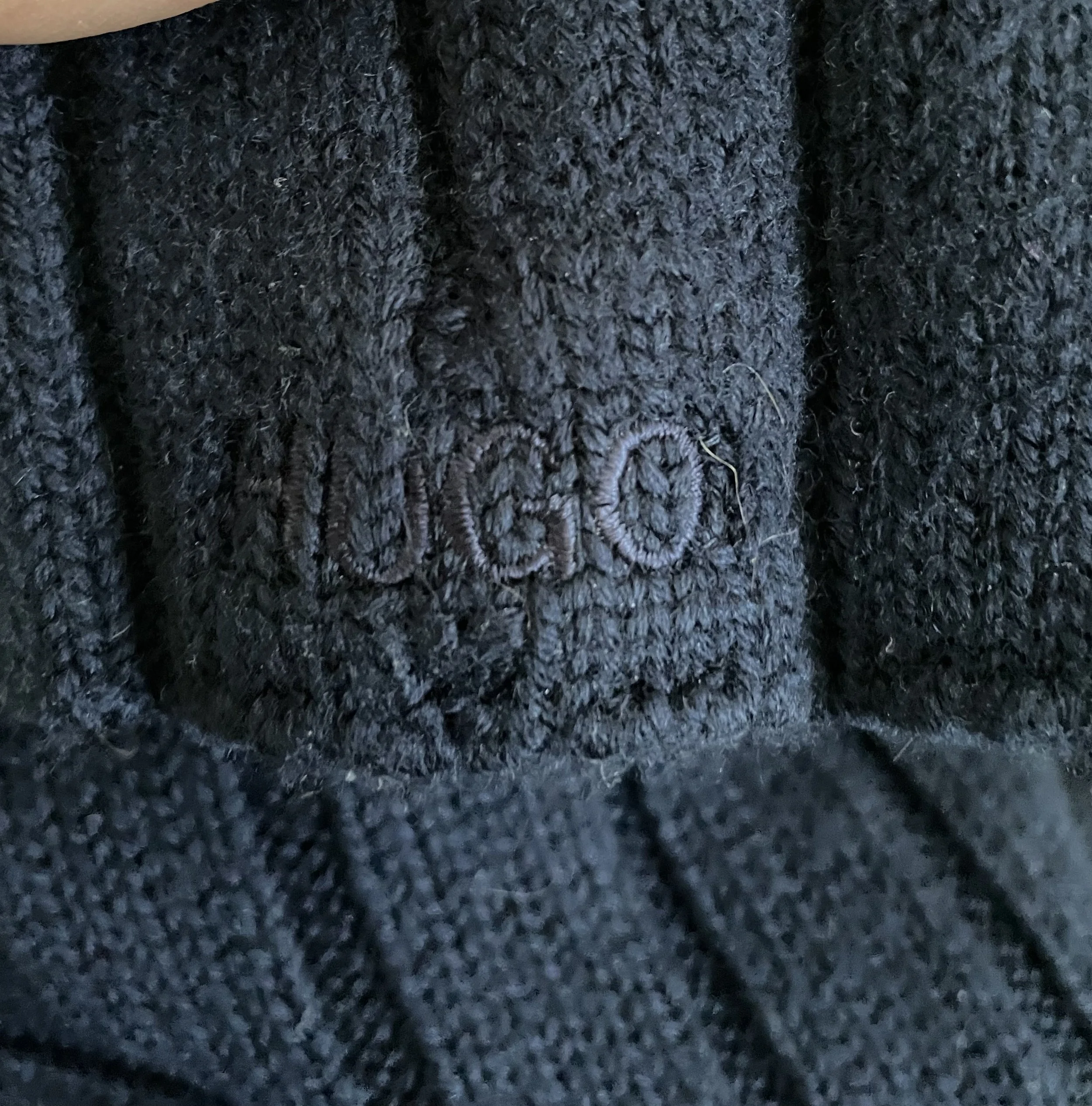 Detail view of the Hugo Boss wool turtleneck hem, showing the precise edge stitching and high-quality finish