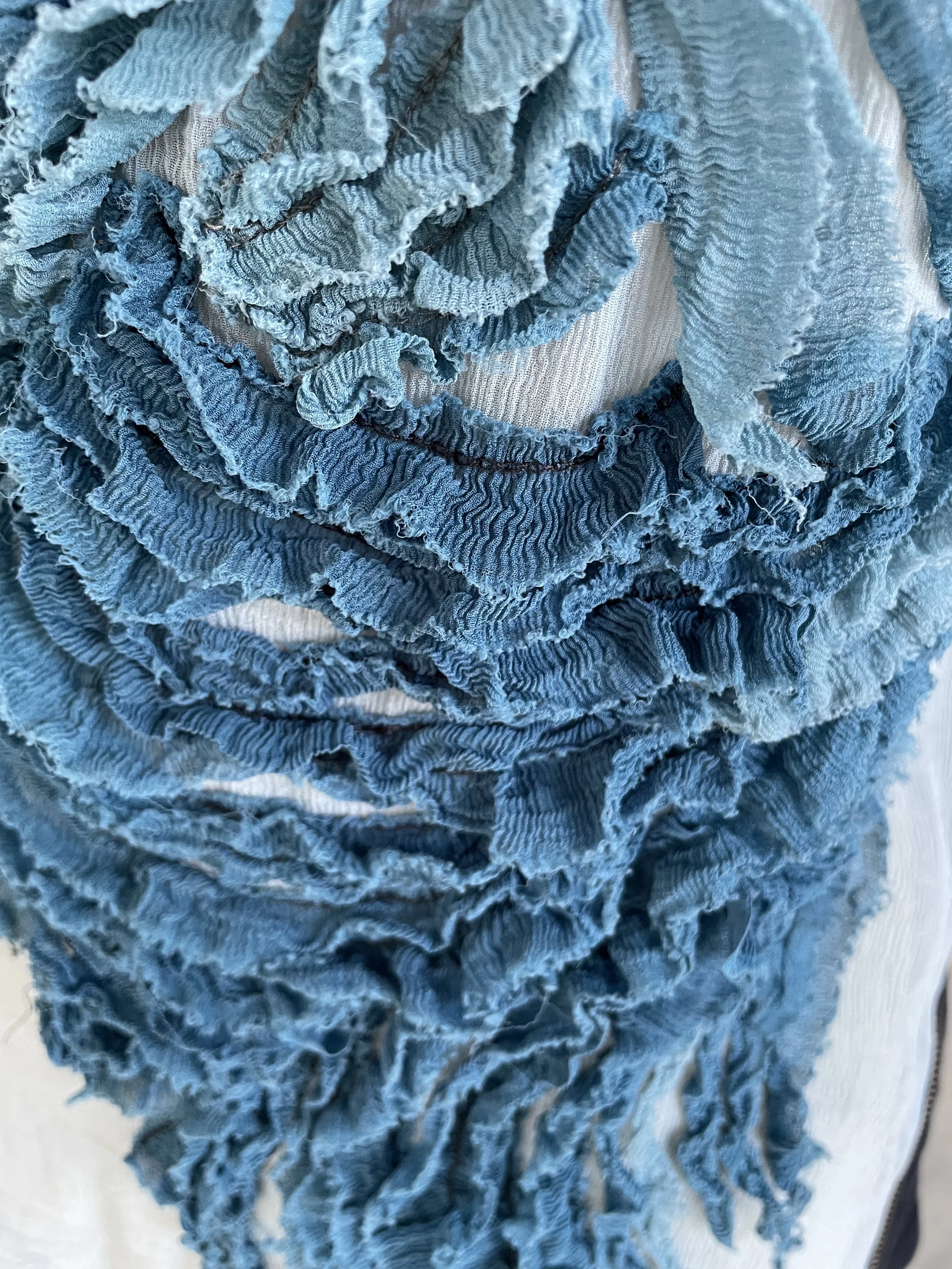 Macro shot of the textured, ruffled blue fabric layers.