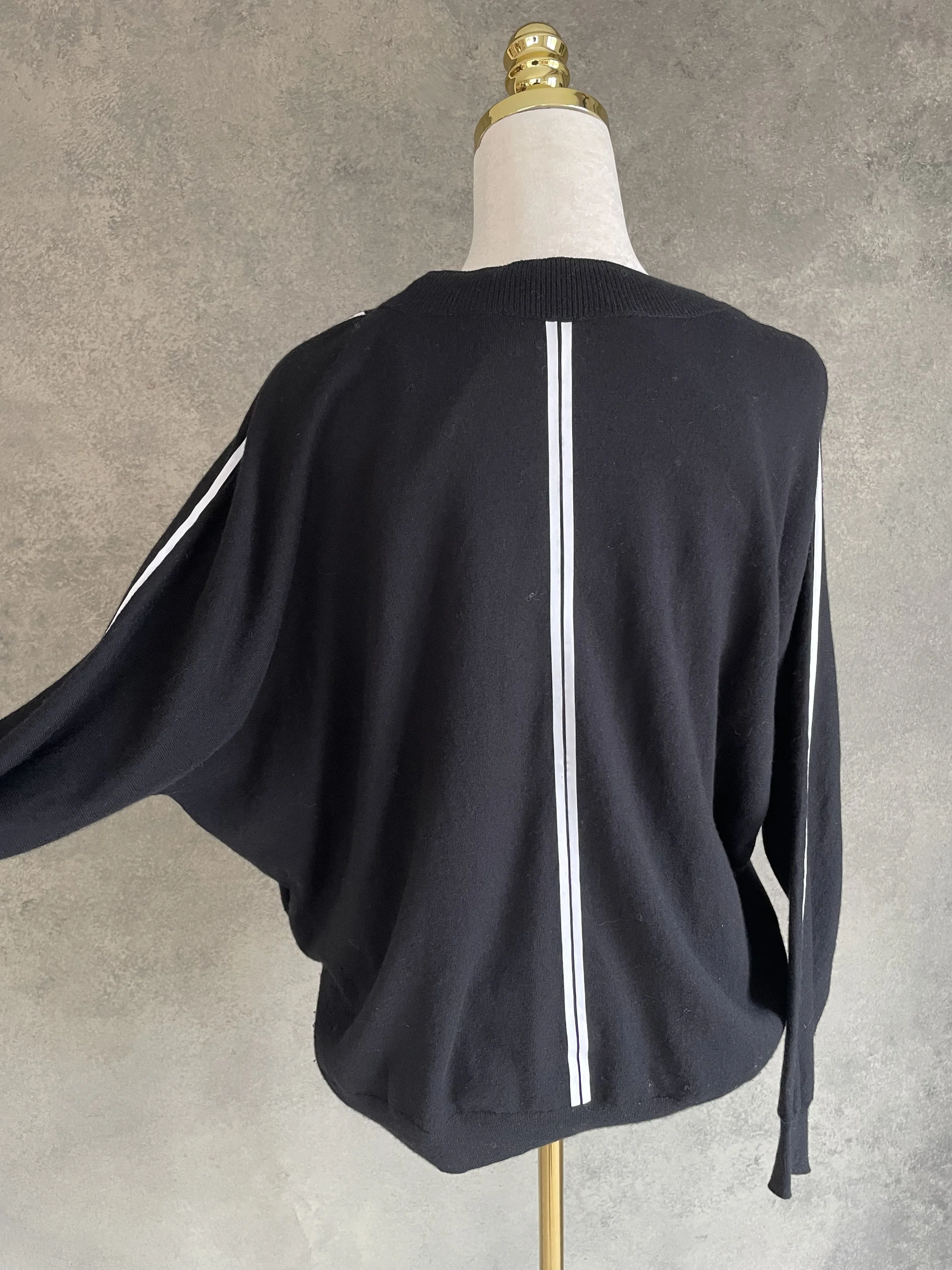 Back view of Marc Cain bat-wing jumper on a mannequin, highlighting the voluminous sleeve silhouette and soft knit texture."