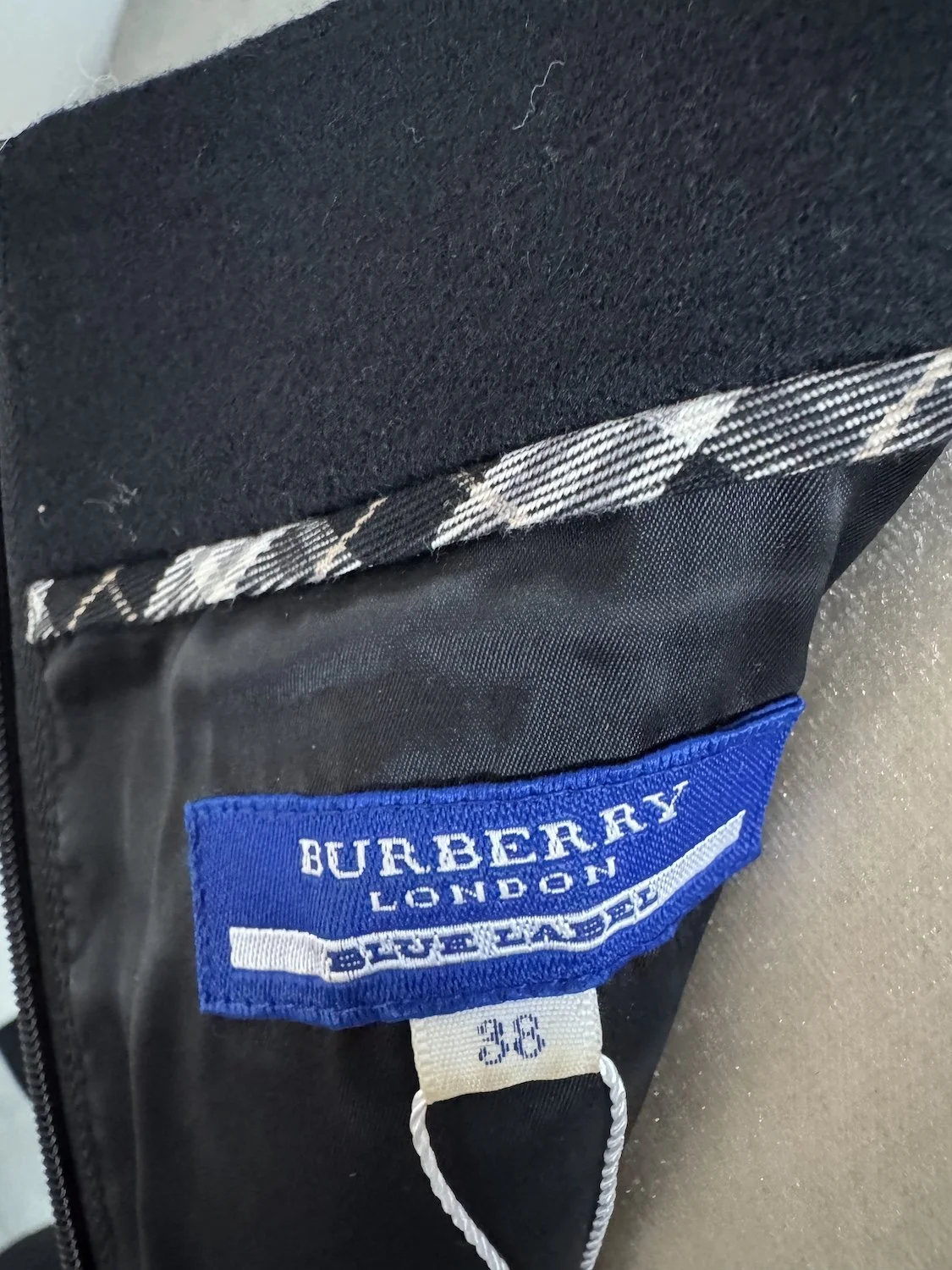 Close-up of the blue Burberry London Blue Label tag and size 38 label.