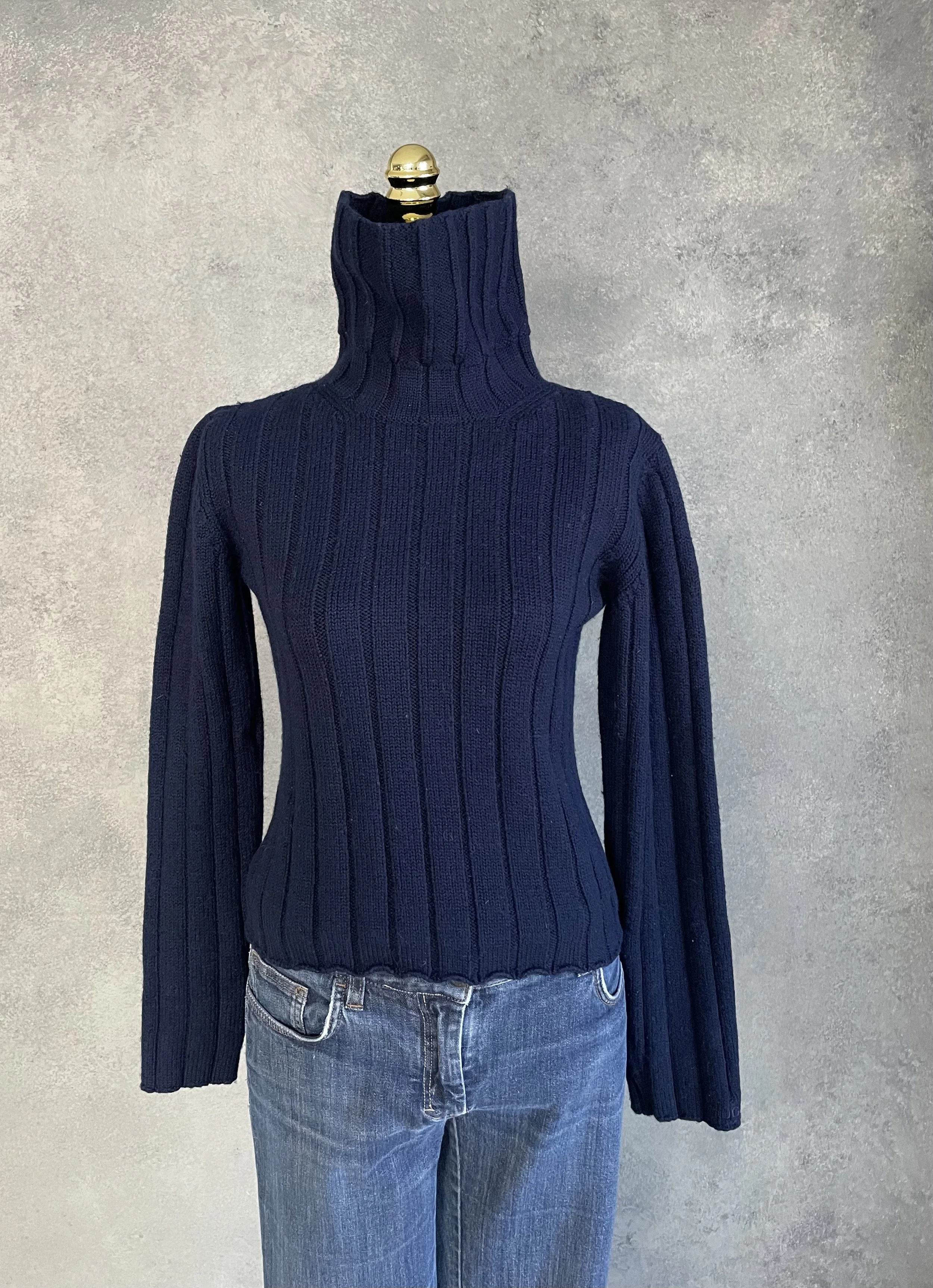 Hugo Boss navy blue wool turtleneck sweater styled on a mannequin, showcasing a classic, refined silhouette