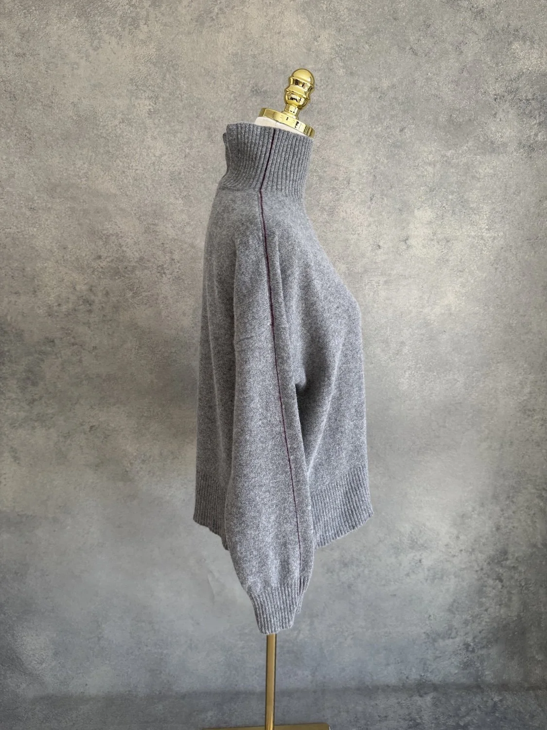 Side view of the sweater showing the path of the contrast line along the shoulder and arm