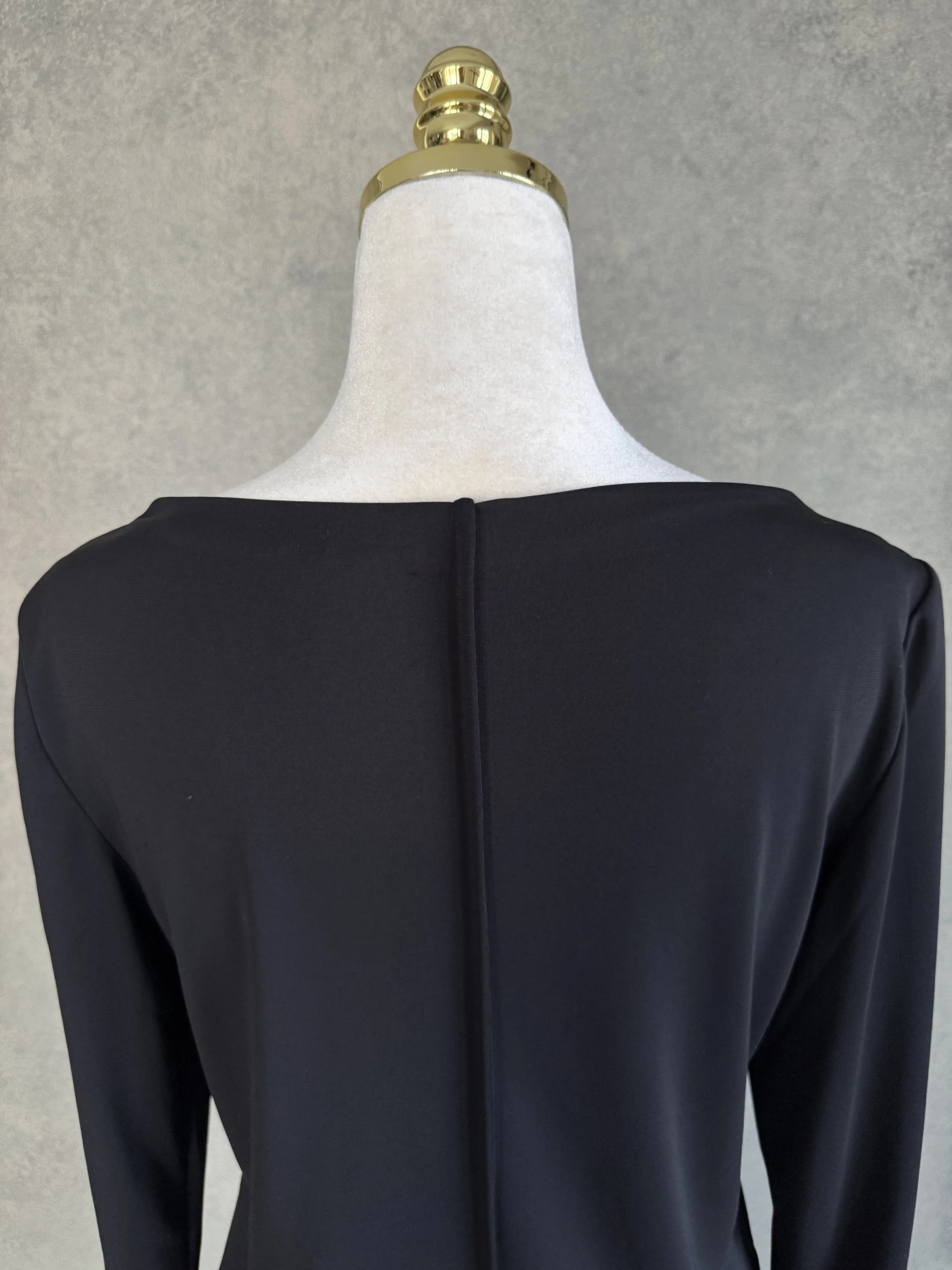 Close-up of the upper back neckline and central seam detail on the black Filippa K dress.