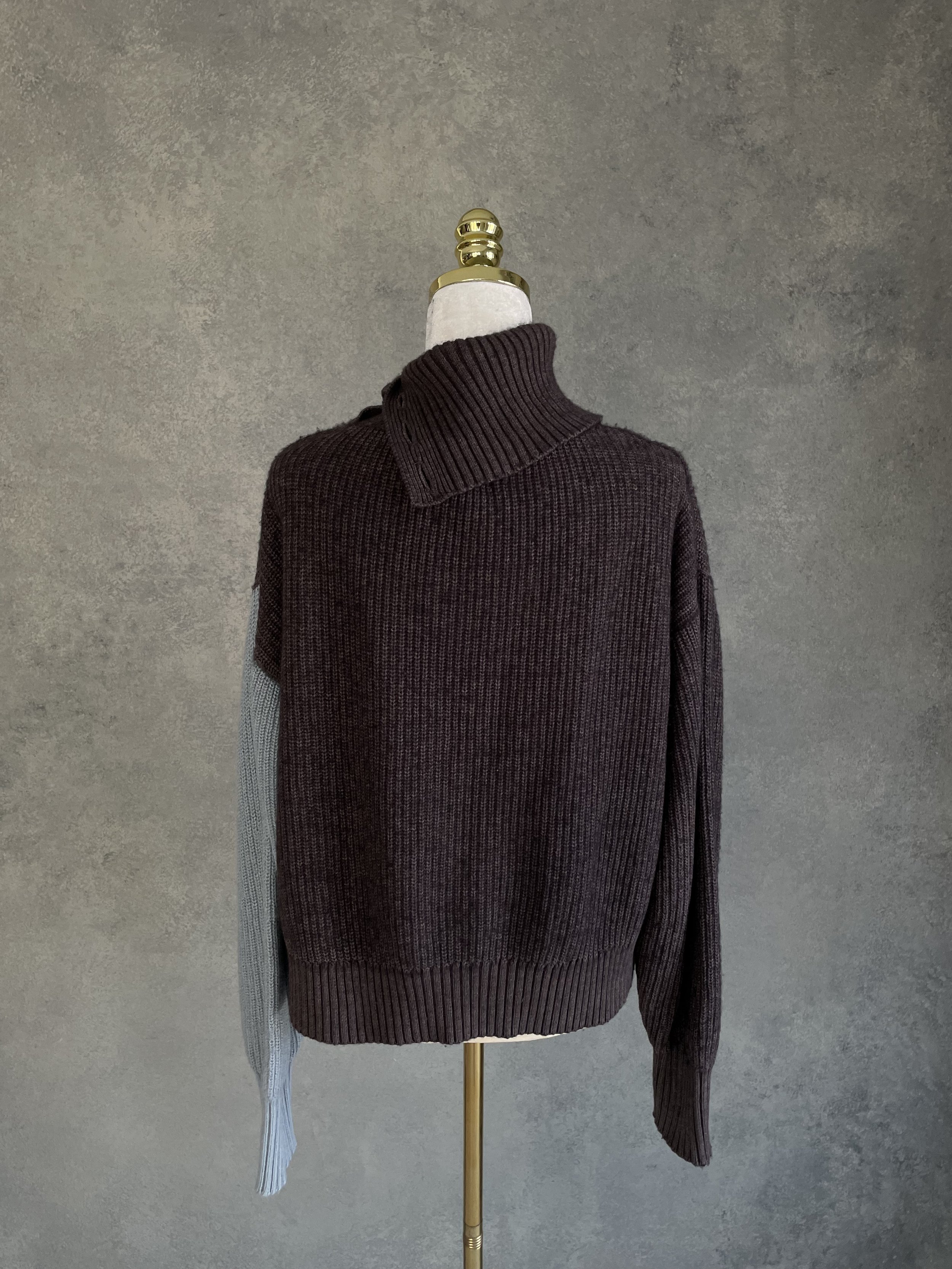 Rear view of the Blanche sweater displaying the adjustable collar design and ribbed hem.