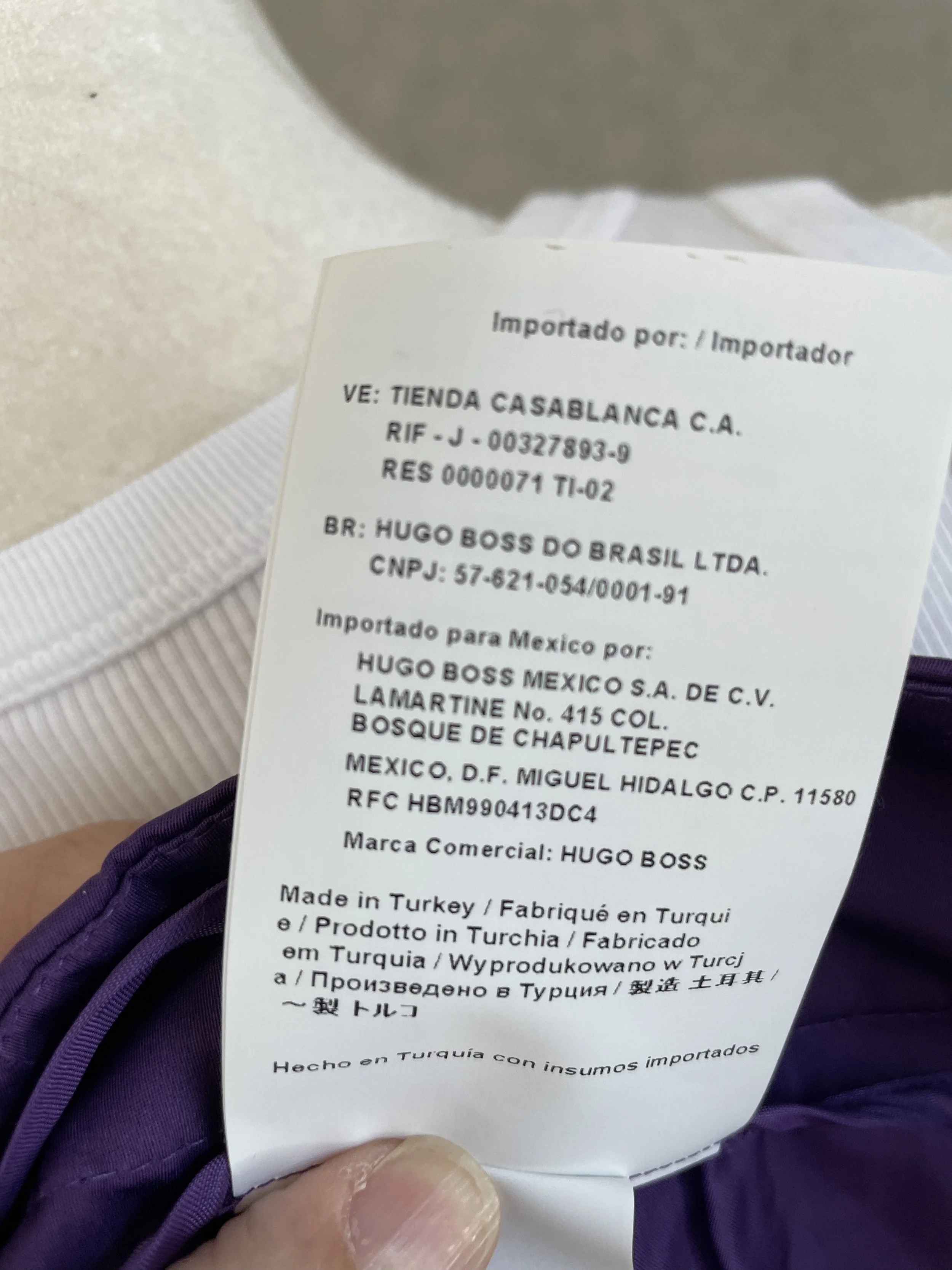 Detailed view of the manufacturing and origin information tag on the purple pencil skirt.