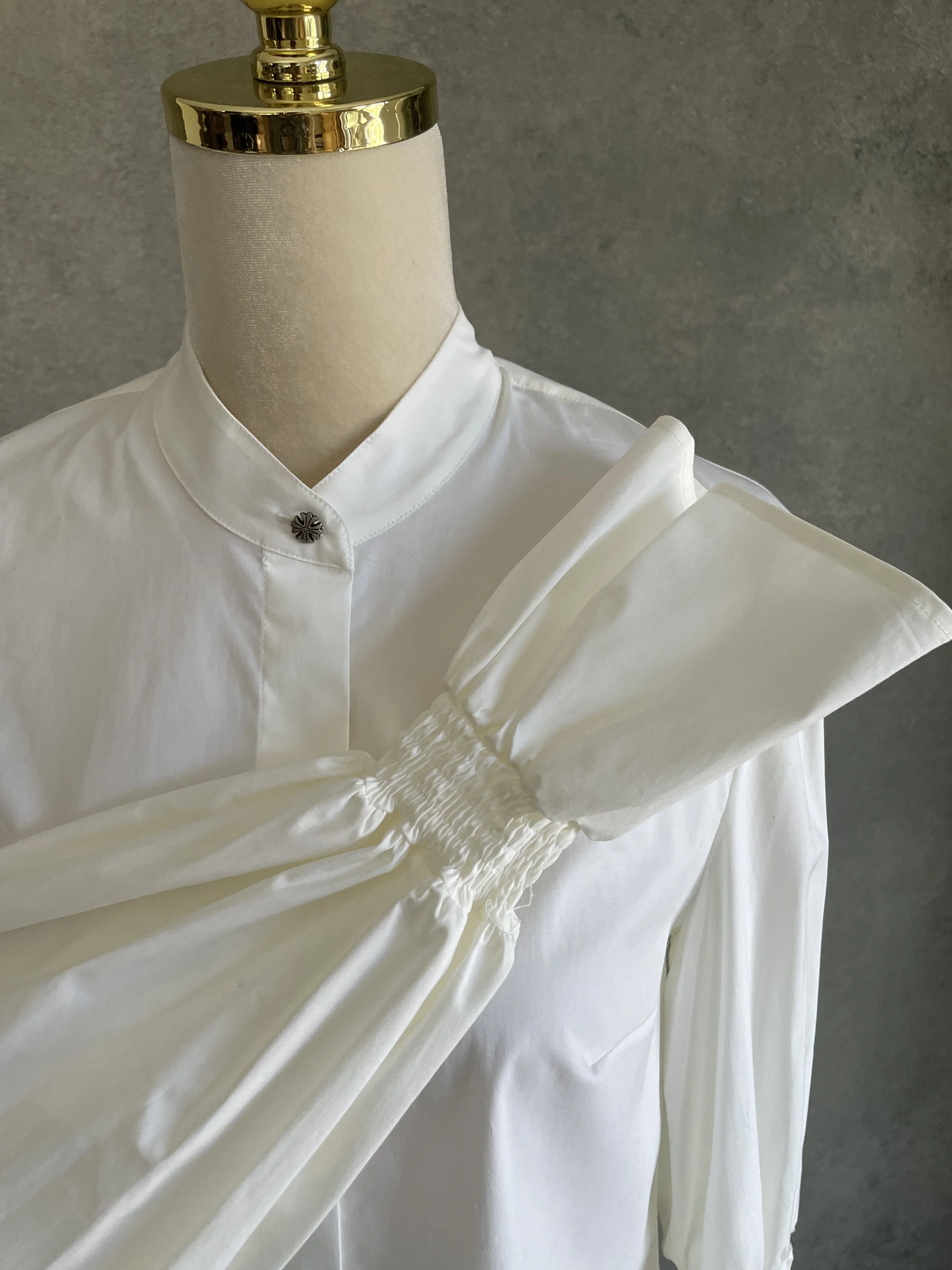 Close-up detail of the gathered ruching and voluminous shape on the sleeve of the white Dondup shirt.