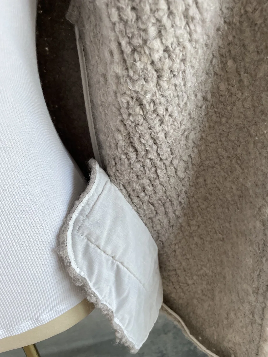 Interior close-up showing the smooth white lining pocket construction inside the side seam of the jacket.