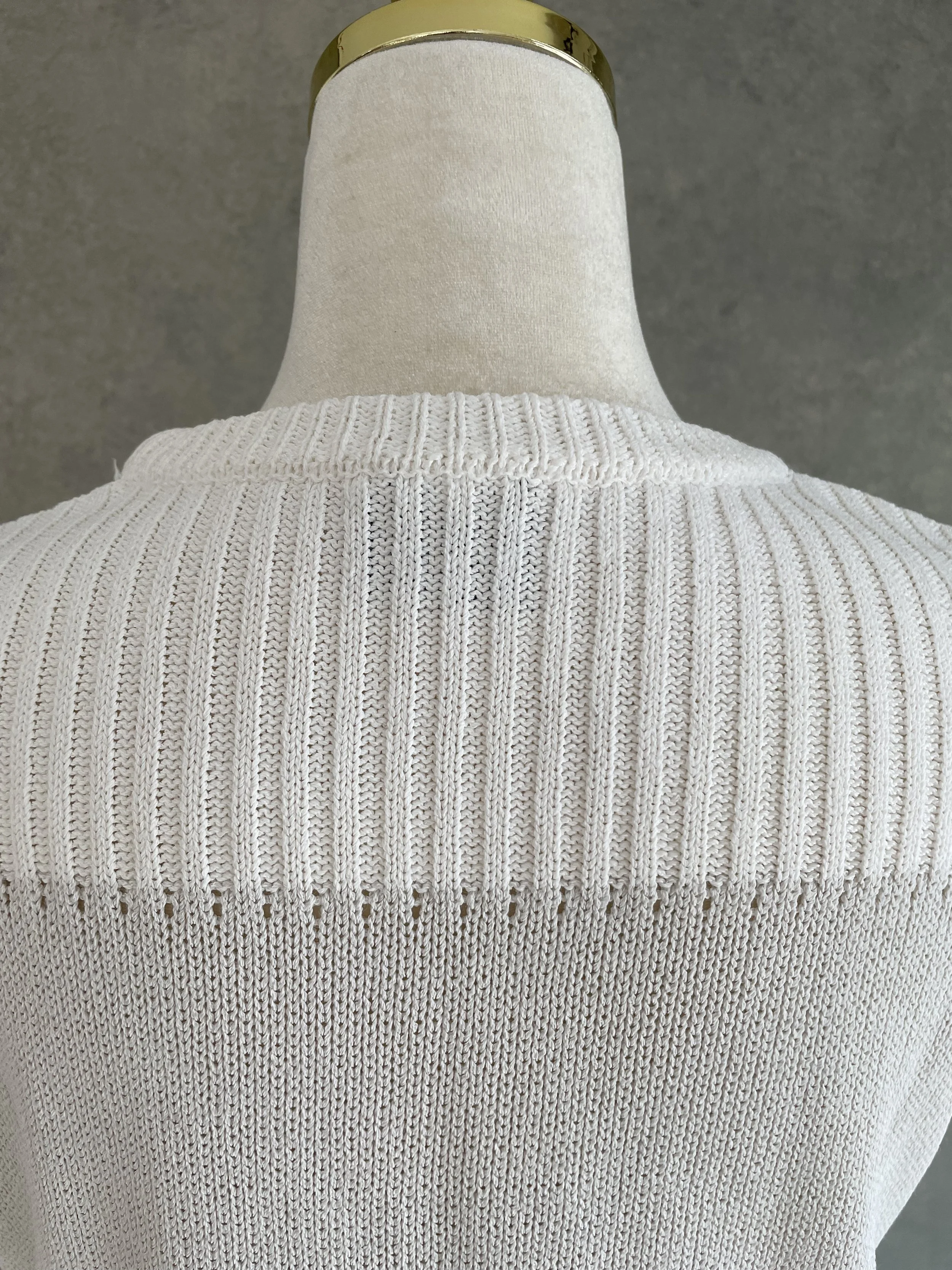 Close-up of the round neckline and textured knit weave of the Natan top.