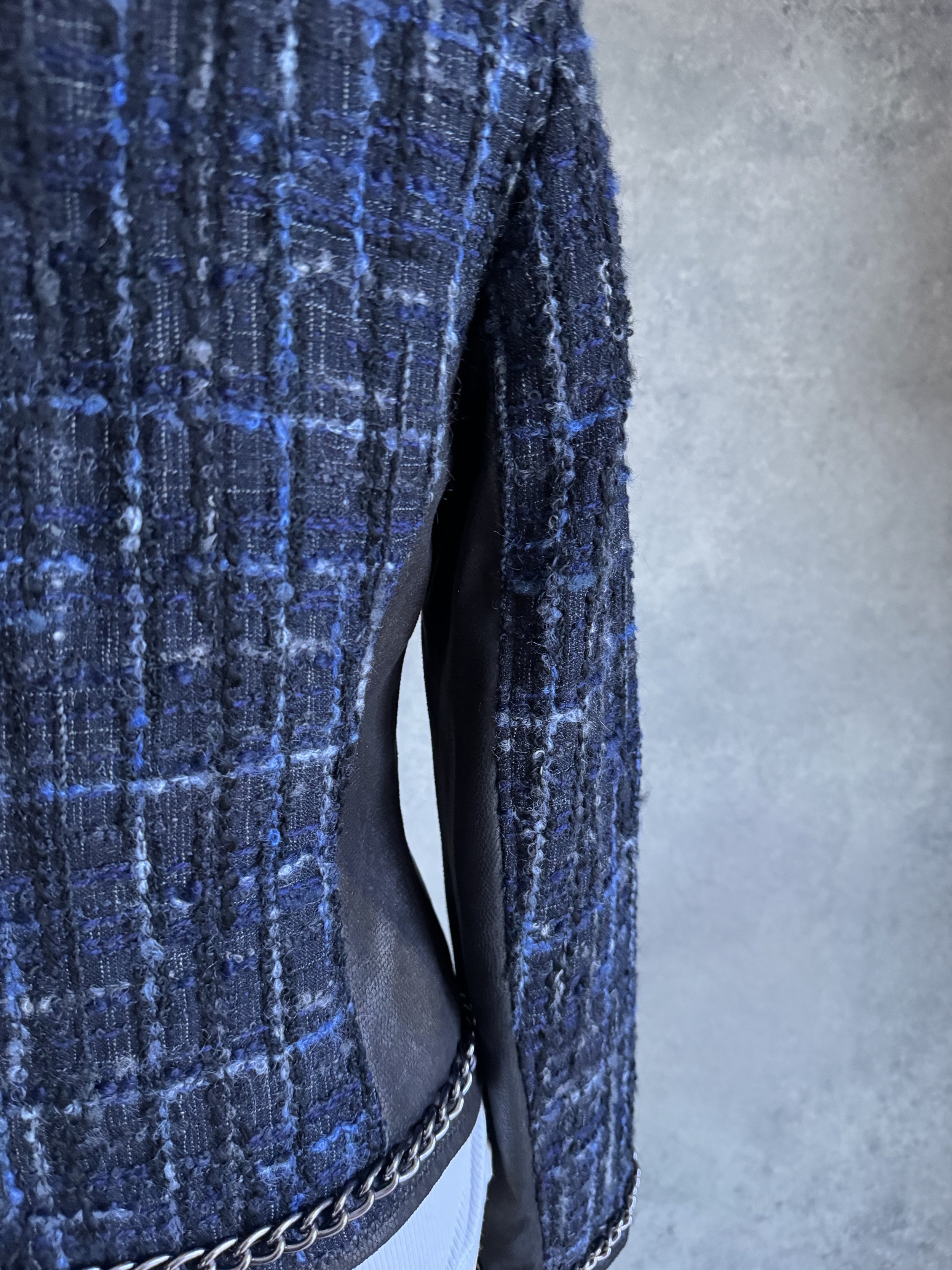 Detailed back view of the Riani blazer showing the tweed fabric texture and chain-link trim at the hem.