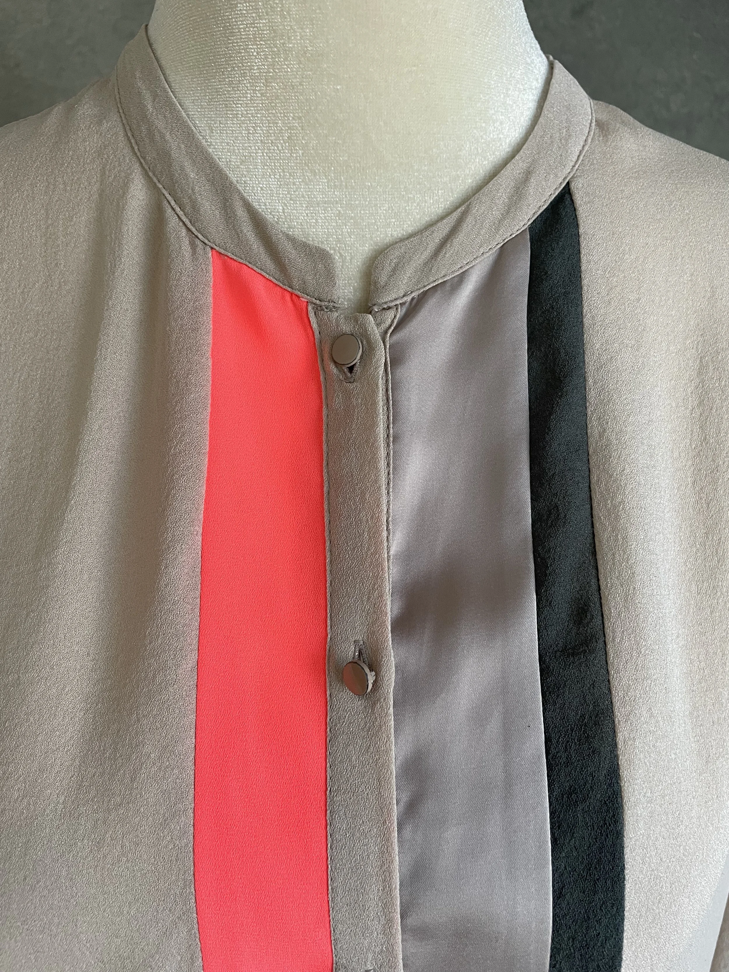 Close-up detail of the Custommade blouse neckline and orange panel, showing the clean construction and high-end silk finish