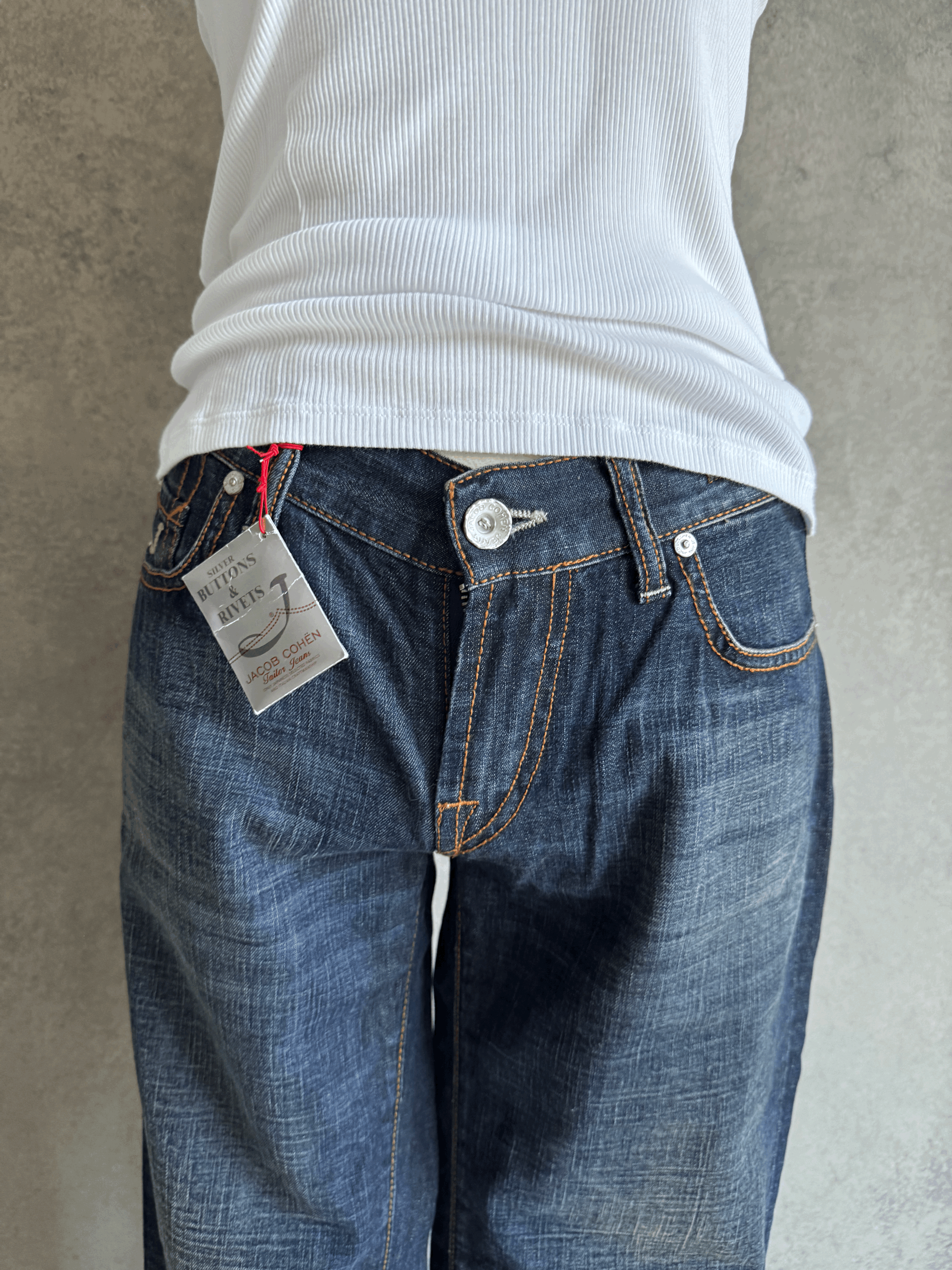 Close-up of the front waist and tag area of Jacob Cohën Japanese denim jeans on a mannequin, highlighting the NWT label.