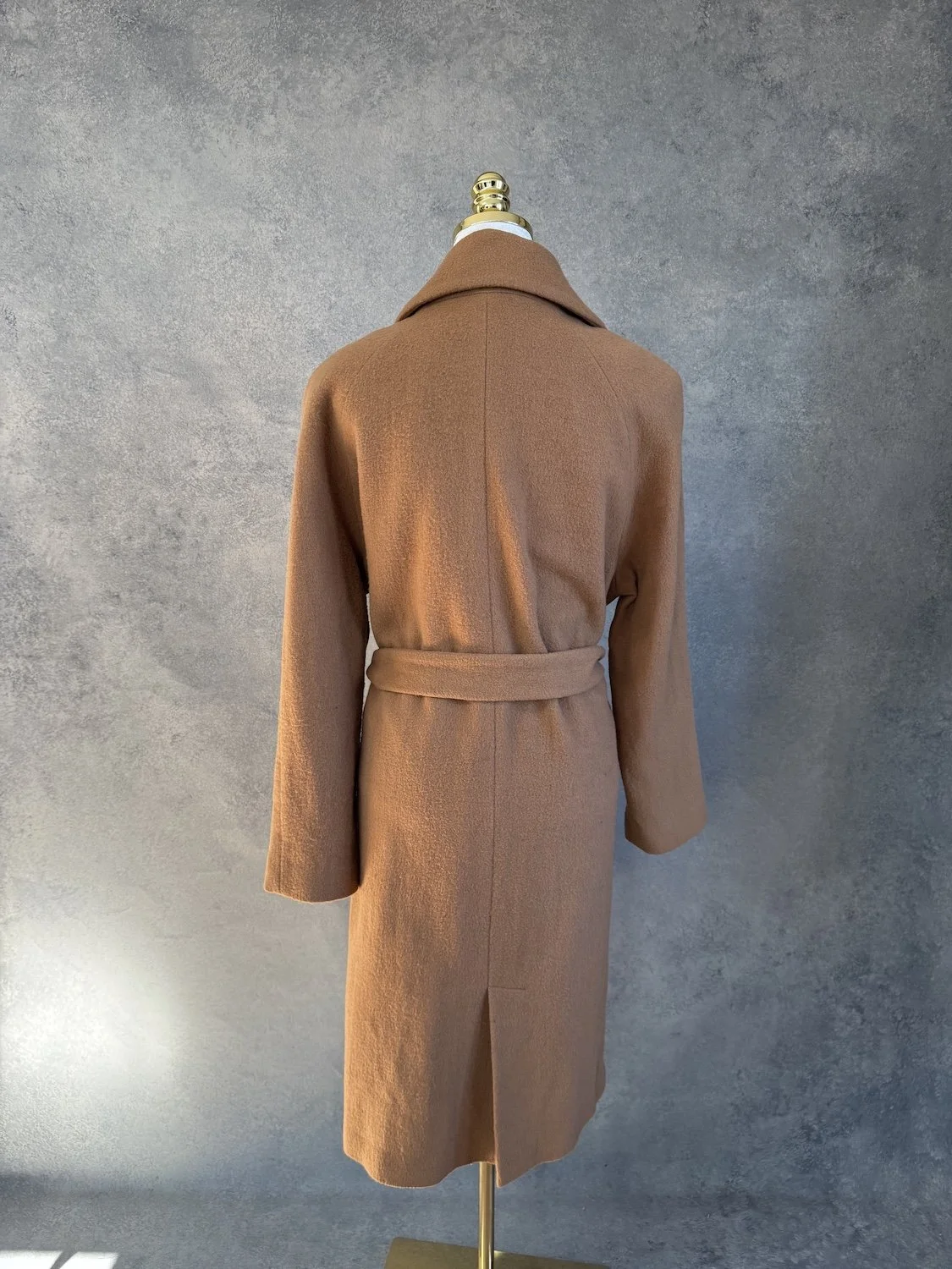 Full side profile view of the coat against a grey studio backdrop.