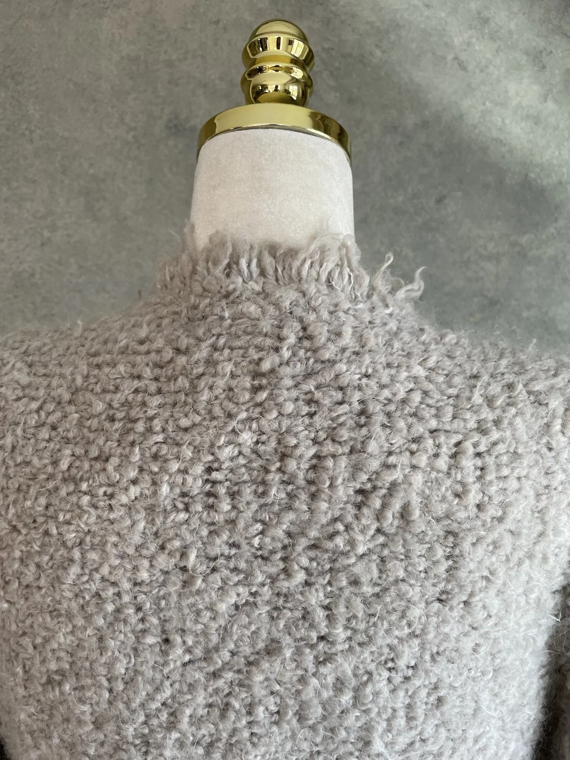 Close-up view of the back neckline and upper shoulder area, emphasizing the plush wool-blend bouclé loop texture.