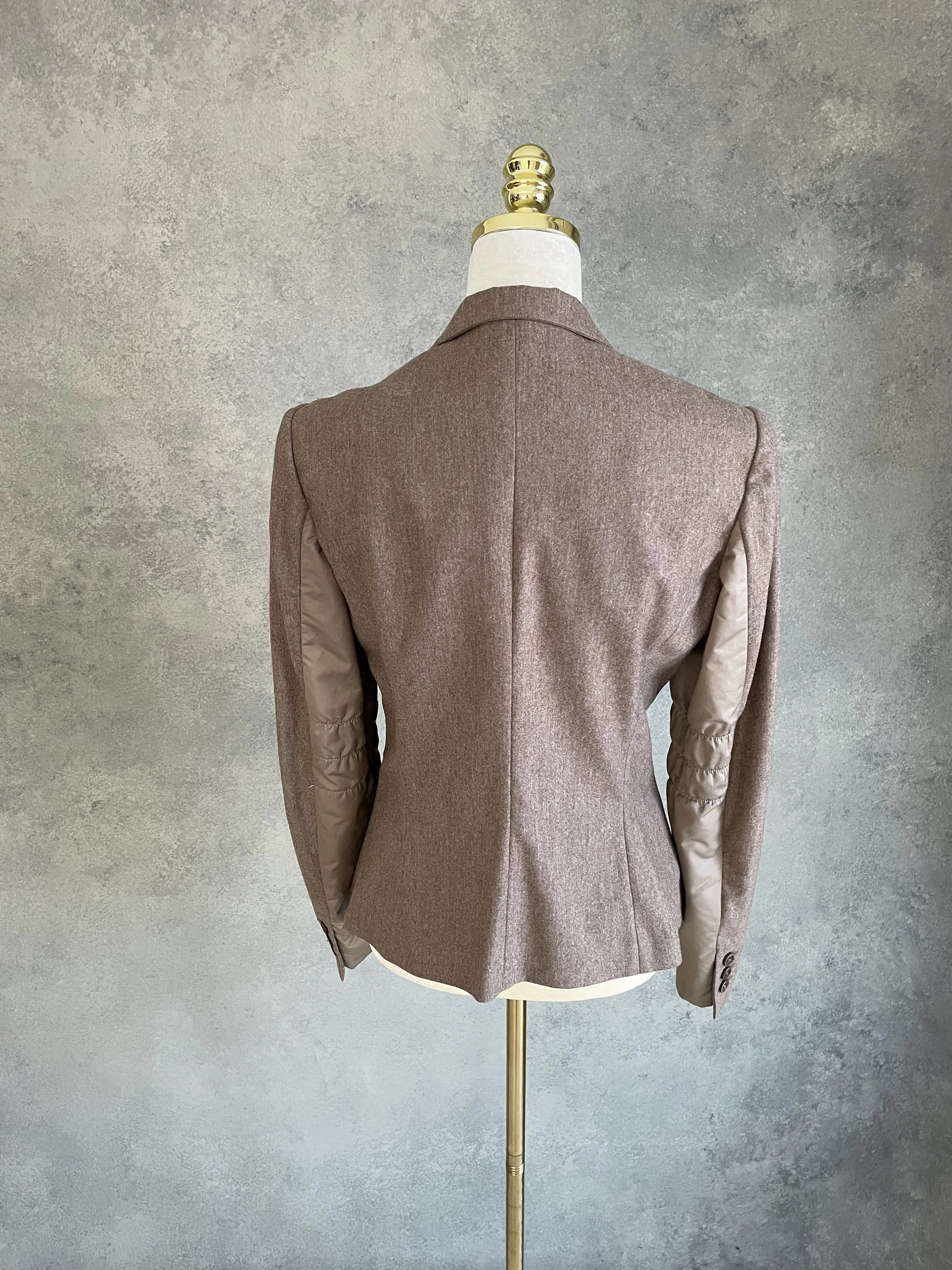 A full rear view of the blazer on the mannequin, showing the back of the jacket and the full visibility of the smooth panels along the side seams.