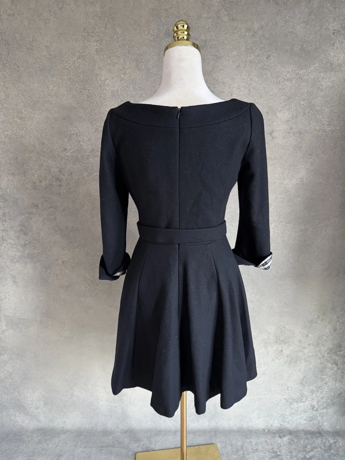 Rear view of the dress showing the back zipper and flared skirt.
