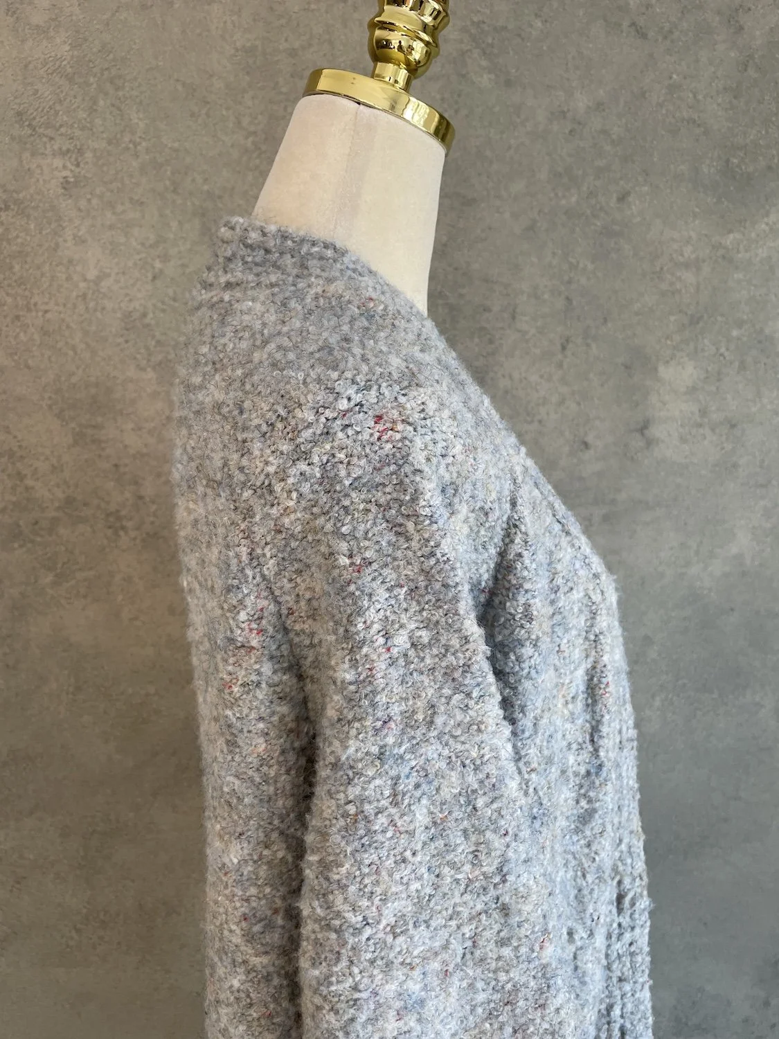 Side profile view of the cardigan on a mannequin, emphasizing the relaxed drop-shoulder cut and long line silhouette.