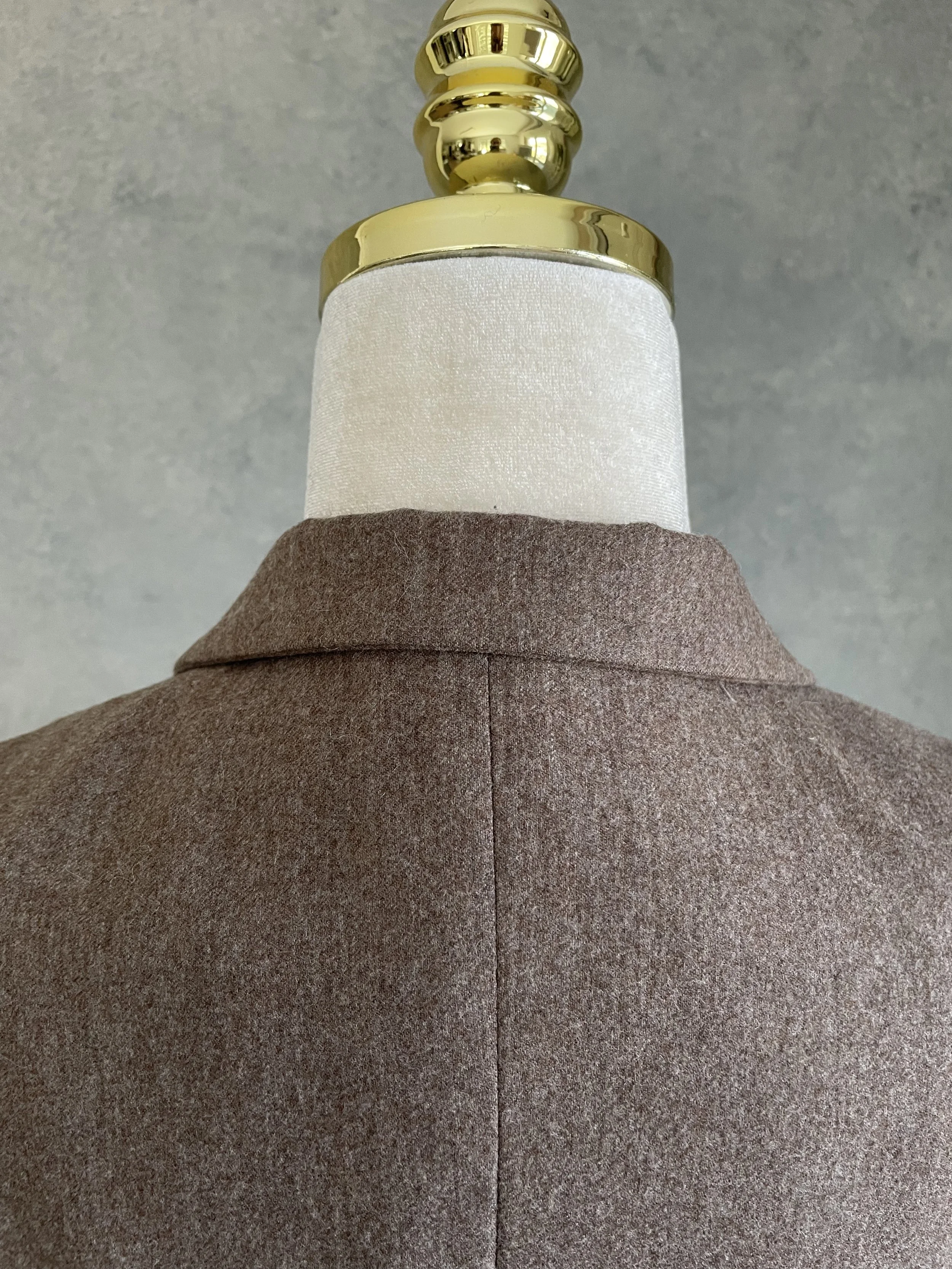 A close-up shot of the back of the blazer's collar and neck area, featuring the continuation of the tailored wool fabric and the precise seam.