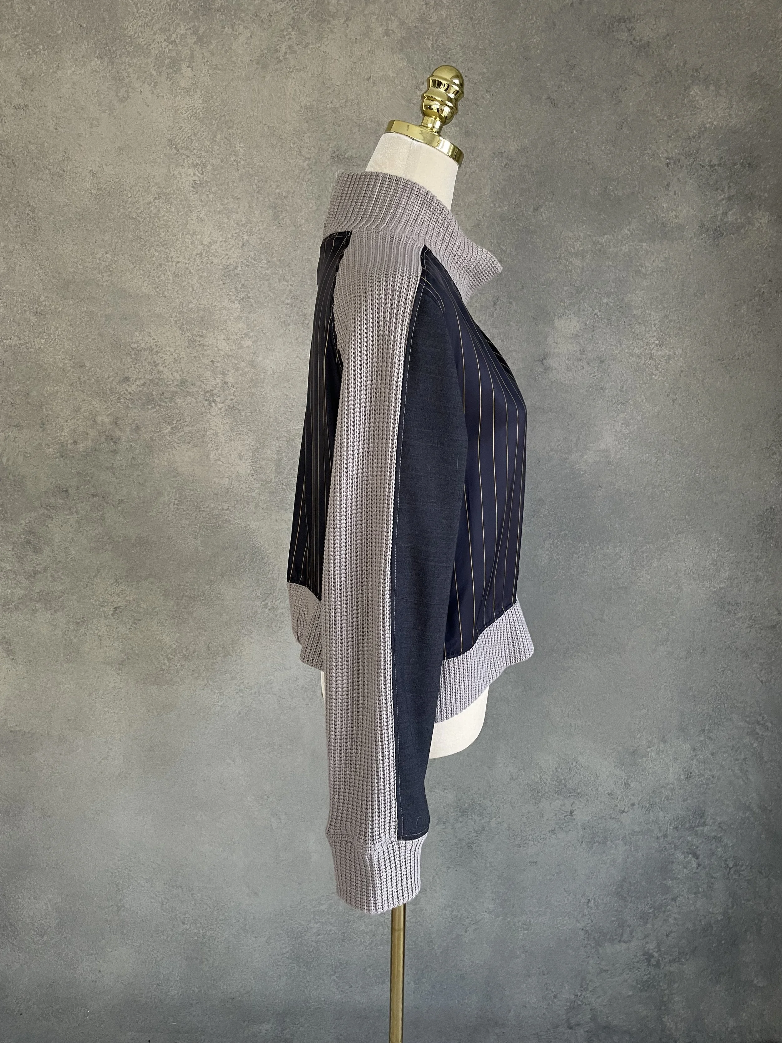VSide profile view of the Vladimir Karaleev architectural sweater, highlighting the panel placement and cropped silhouette.