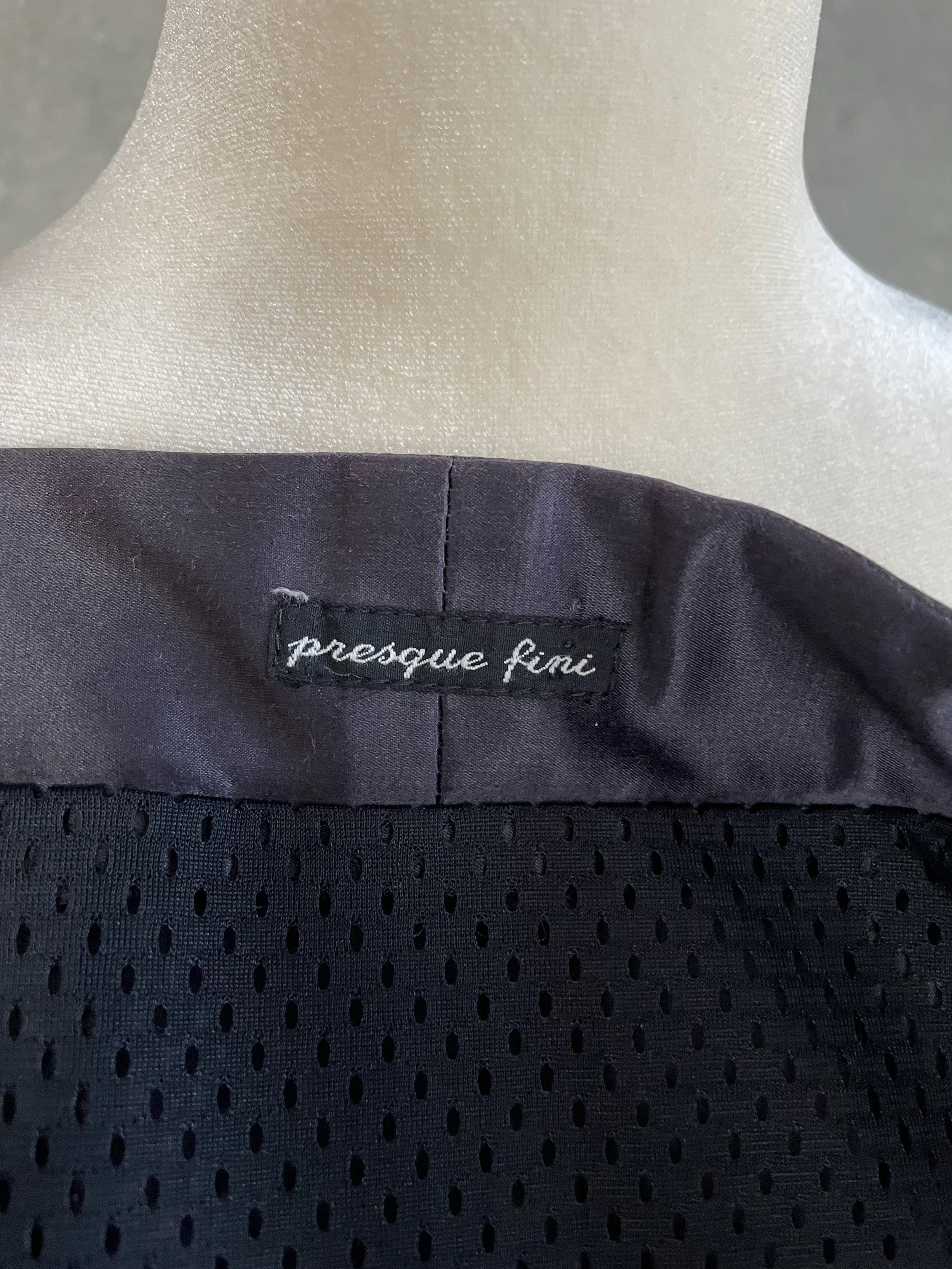 Close-up detail shot of the Presque Fini name tag of the skirt.