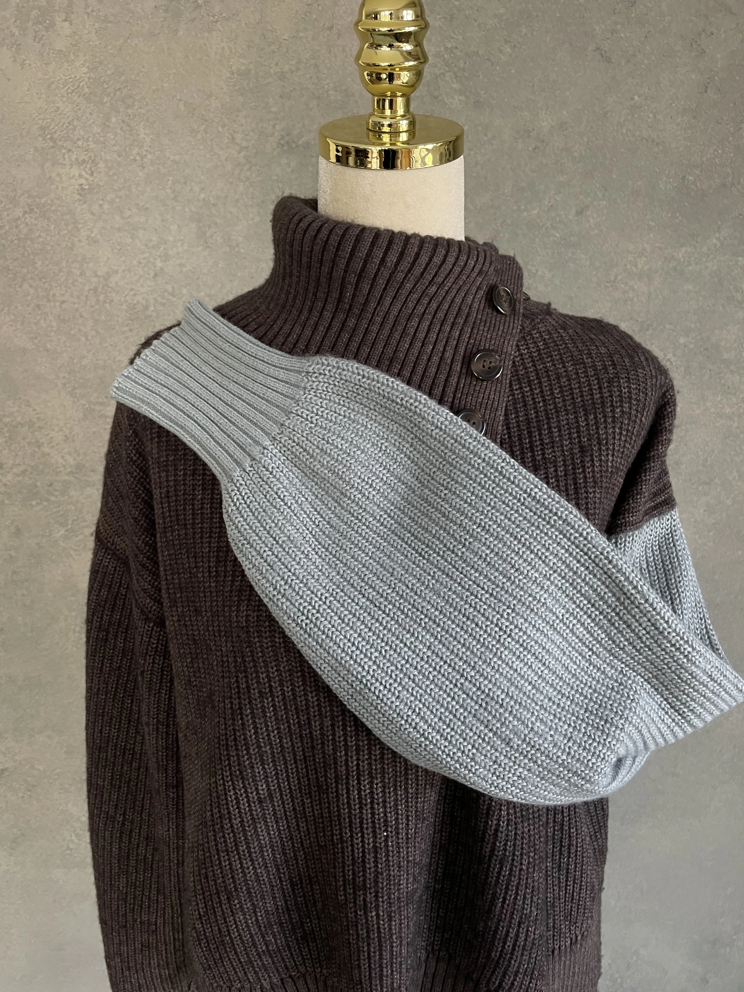 Detail shot showing the folded-over polo neck and button closure of the Blanche sweater.