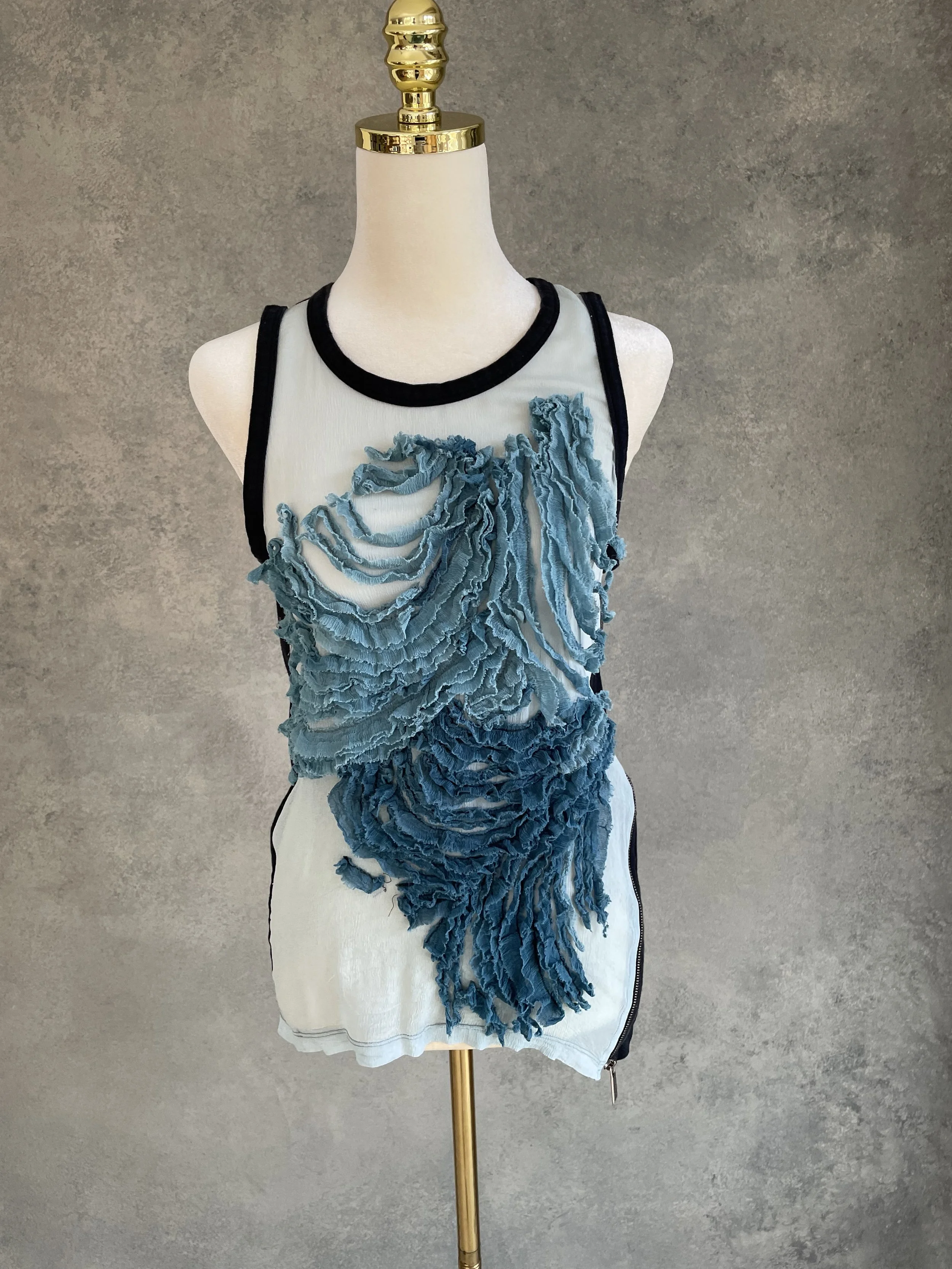 Full front view of the tank top, highlighting the intricate blue ruffled fabric appliqué.