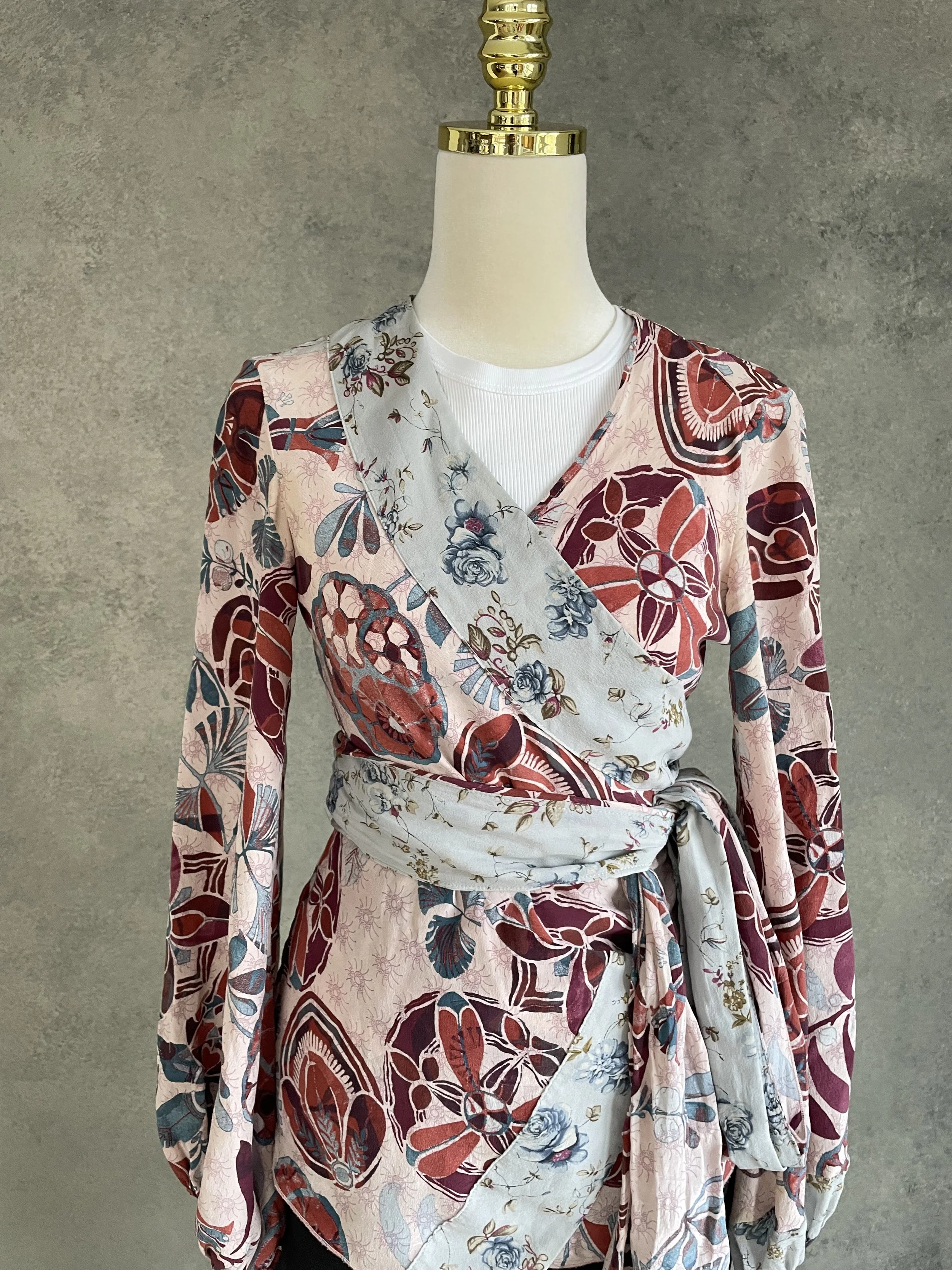 Dondup wrap blouse, highlighting the contrasting pattern of the V-neck lapels and matching fabric sash in grey-blue floral.
