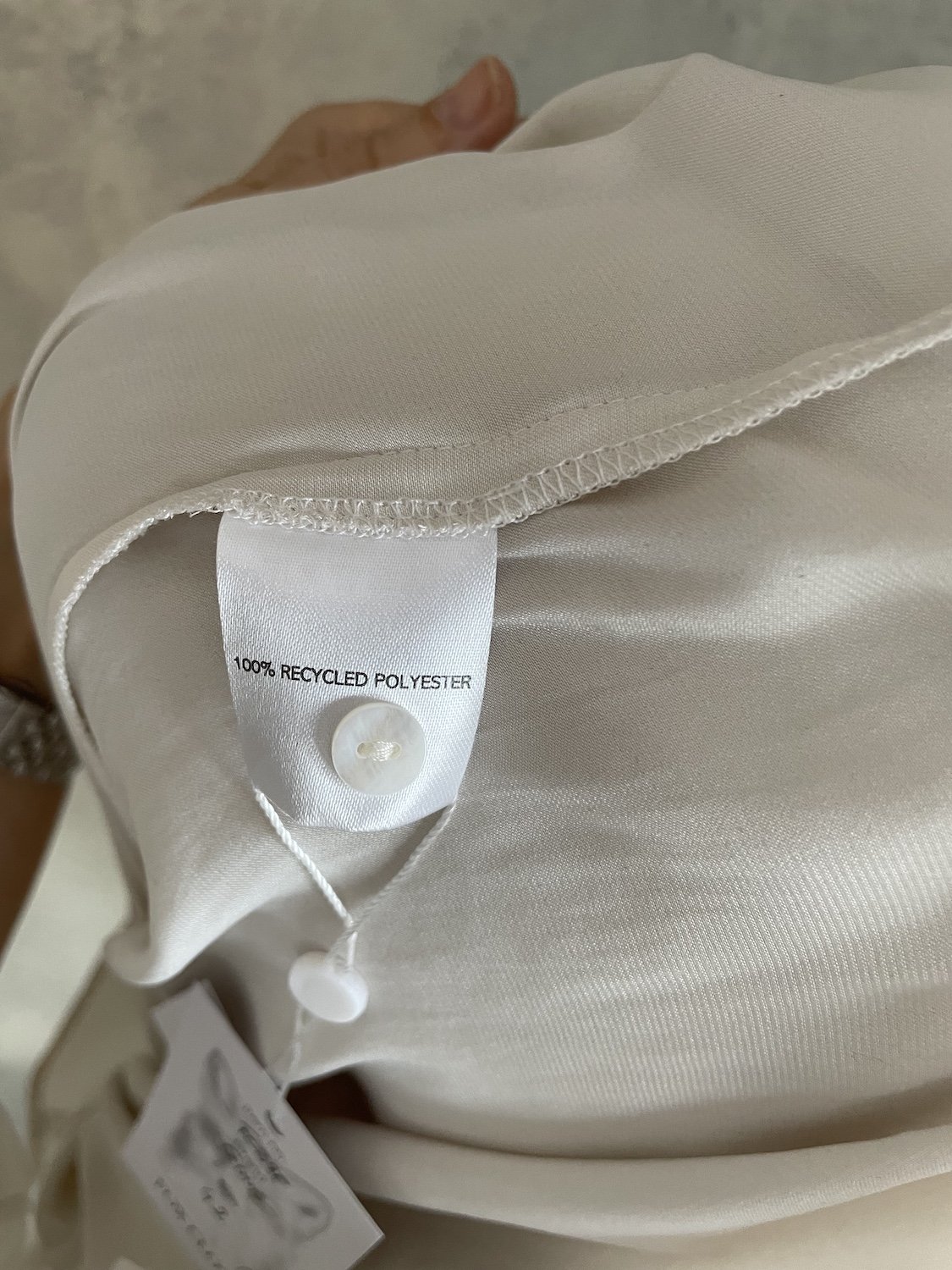 Close-up of the interior tag showing 100% recycled polyester material and care instructions.