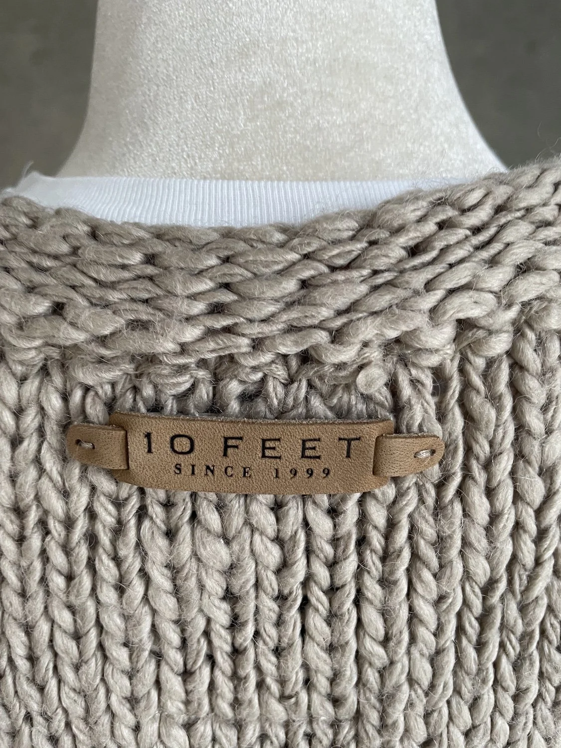 Close-up detail of the debossed leather label "10 Feet Since 1999"