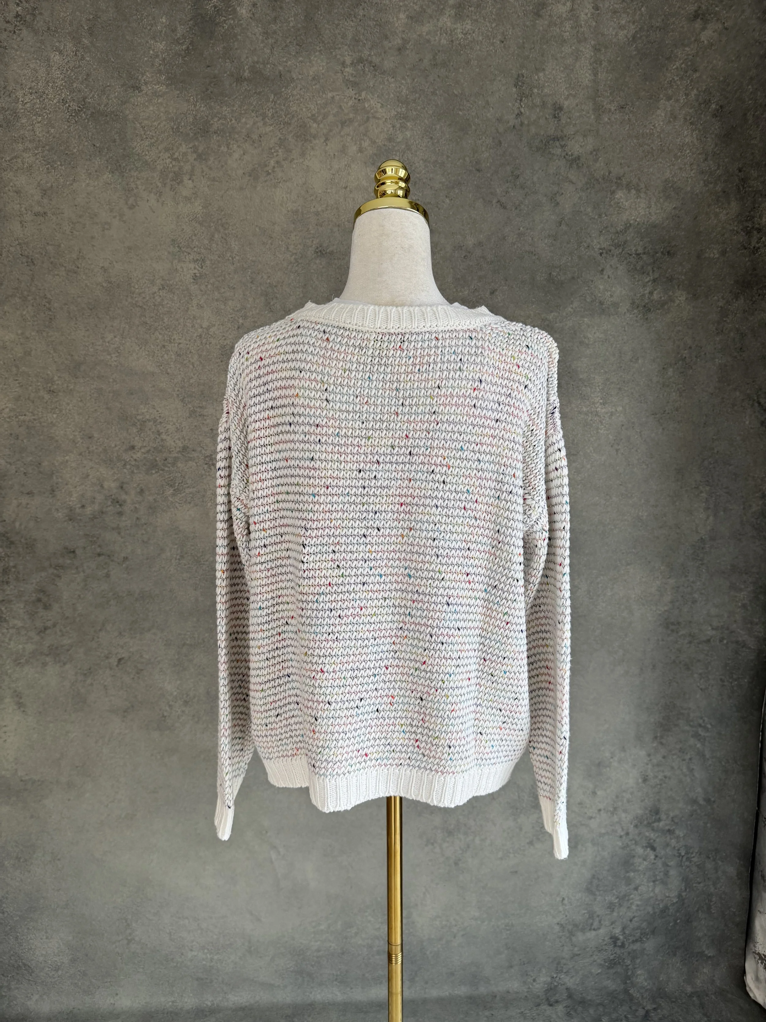 Full back view of the SCAPA FLOW jumper on a mannequin, showing the clean, uniform speckled knit pattern across the rear.