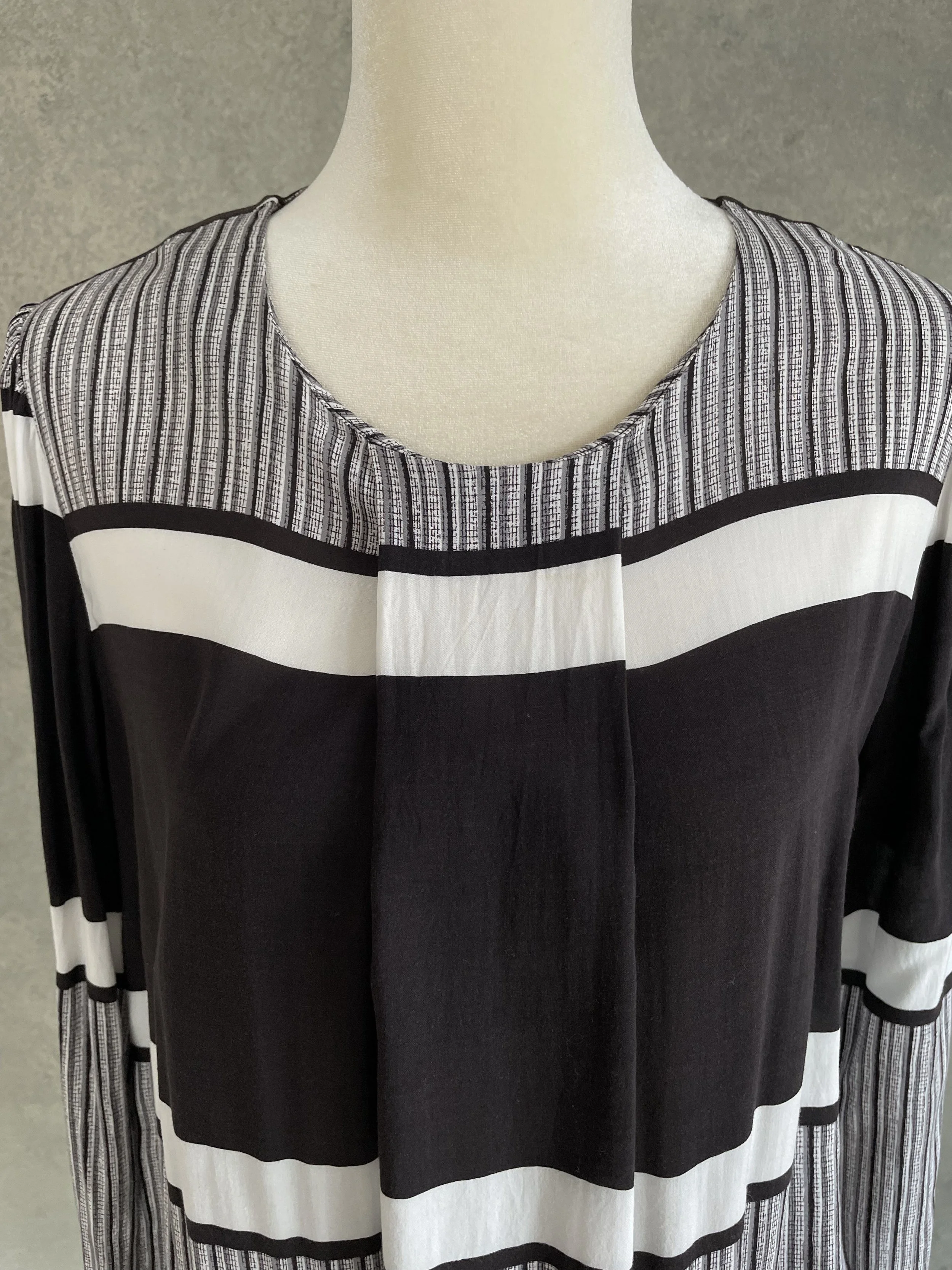Close-up of the front neckline and pleated bodice detail of the Rodebjer graphic black and white blouse.
