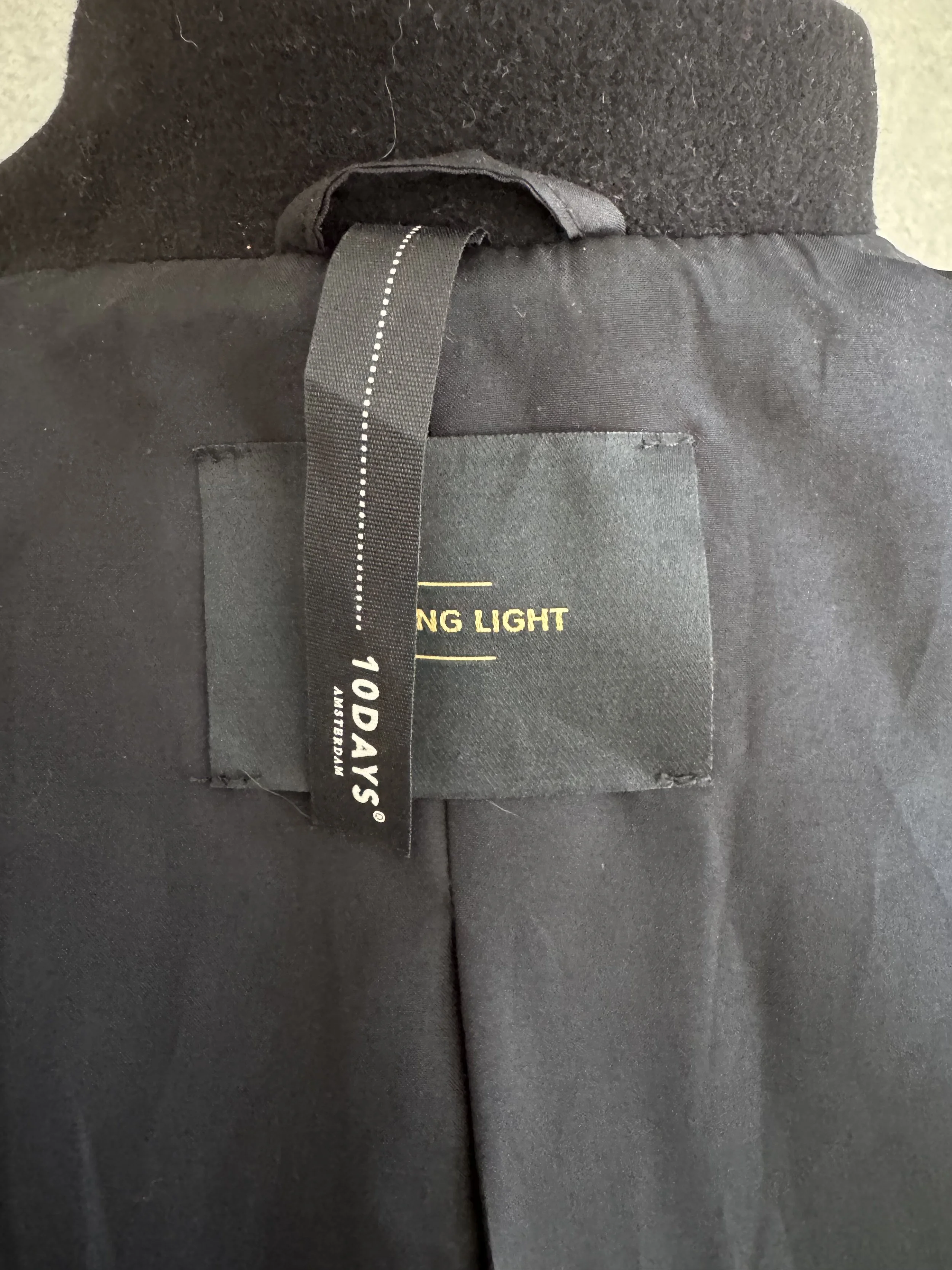 Interior view showing the sewn-in "10DAYS AMSTERDAM" main label and "STAYING LIGHT" branding loop