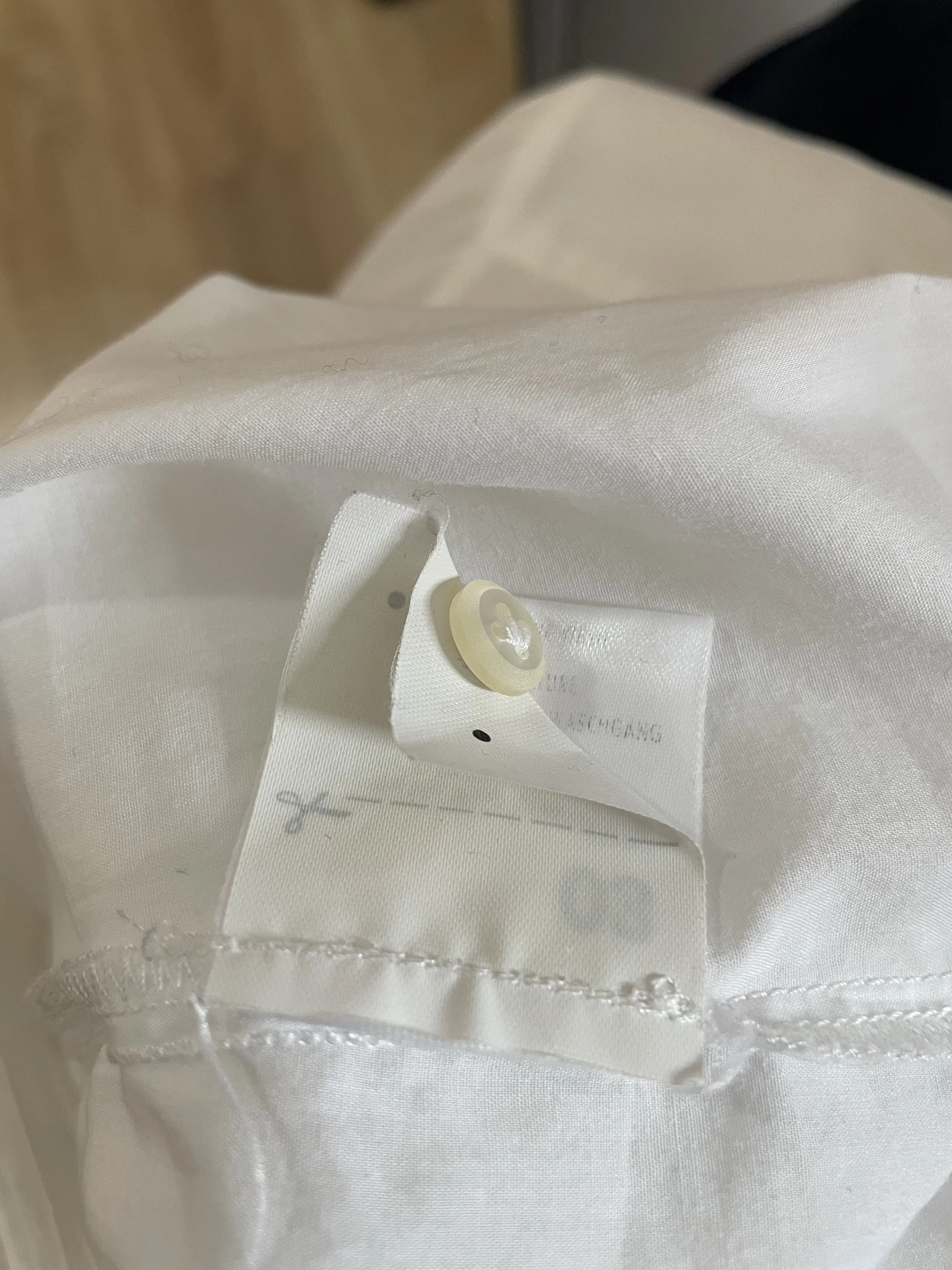 Close-up of the interior tag with a spare button attached."