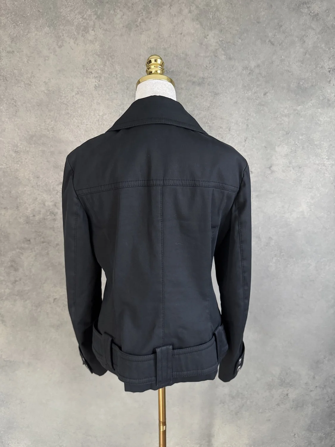 Rückansicht der schwarzen Laurèl Bikerjacke mit breitem Bund und Gürtelschlaufen am Saum.