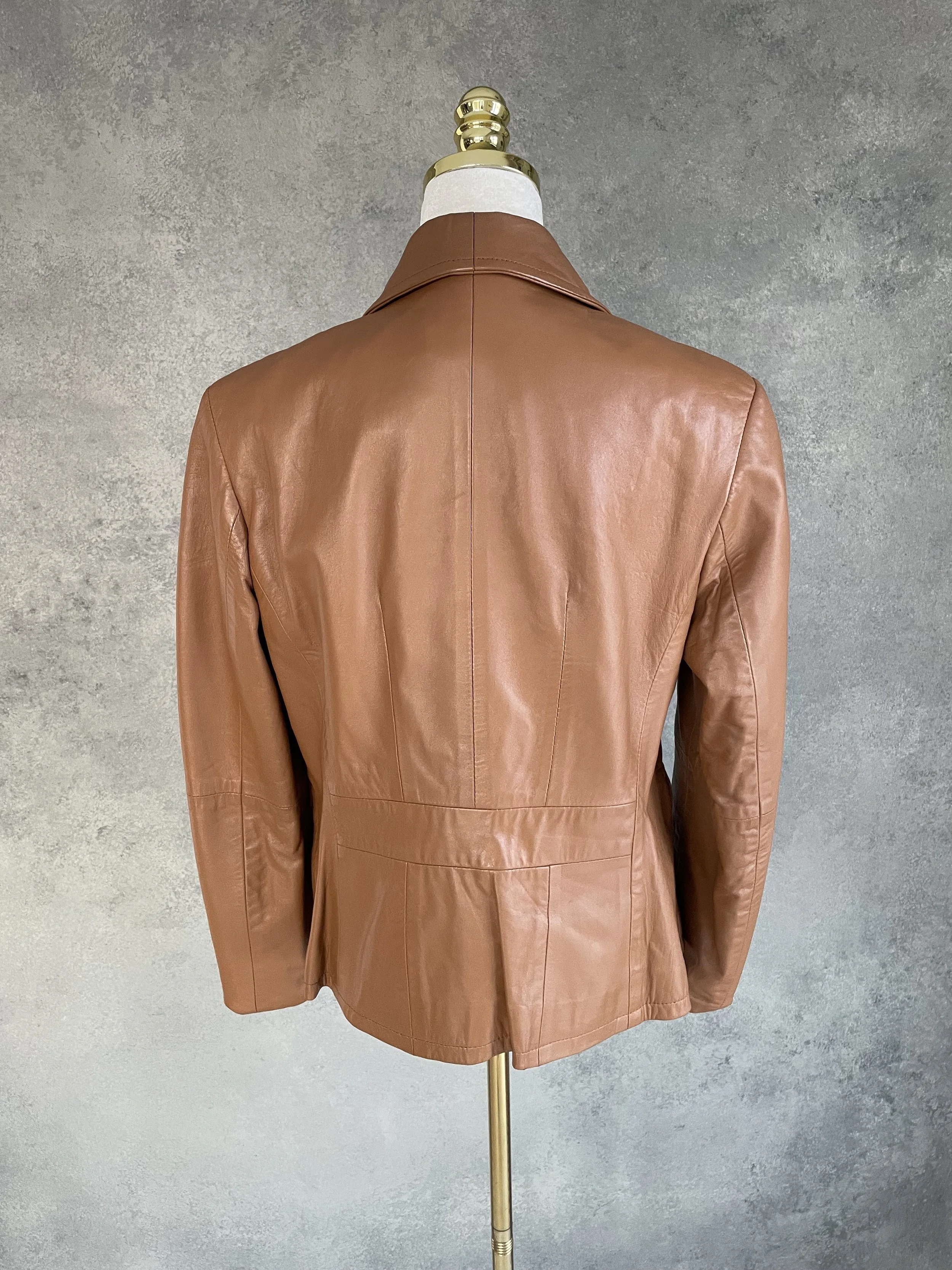 Full back view of the Aust cognac leather jacket on a mannequin, illustrating the relaxed fit, comfortable silhouette, and consistent leather quality