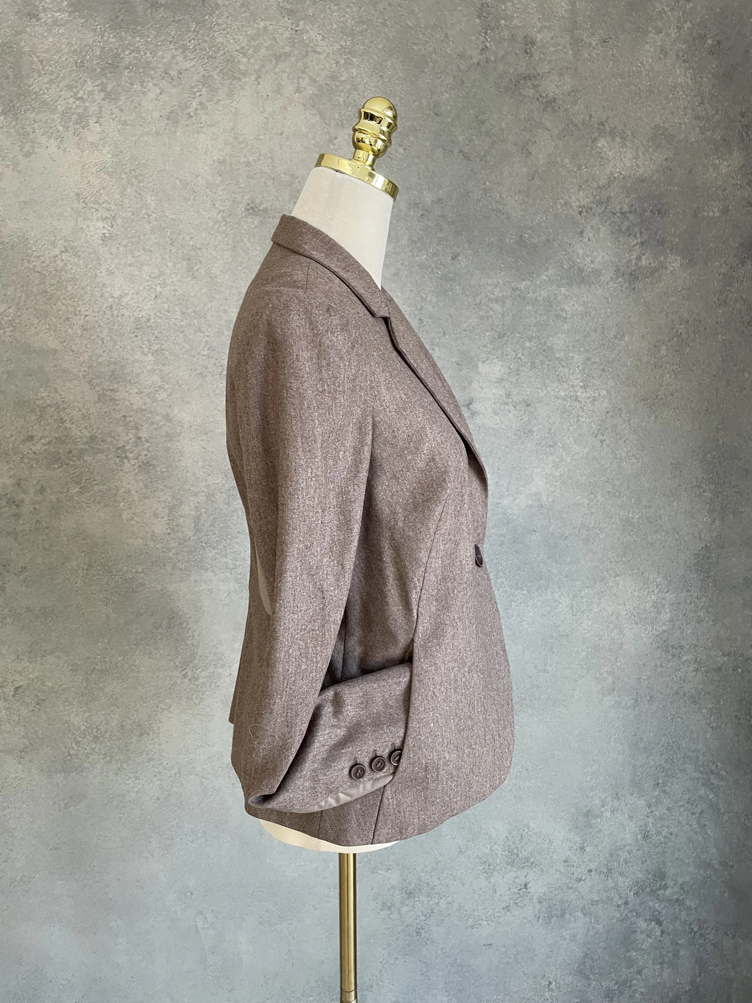 A side view of the blazer on the mannequin, showing the fit and silhouette, and emphasizing the sporty, functional aesthetic of the side panels.
