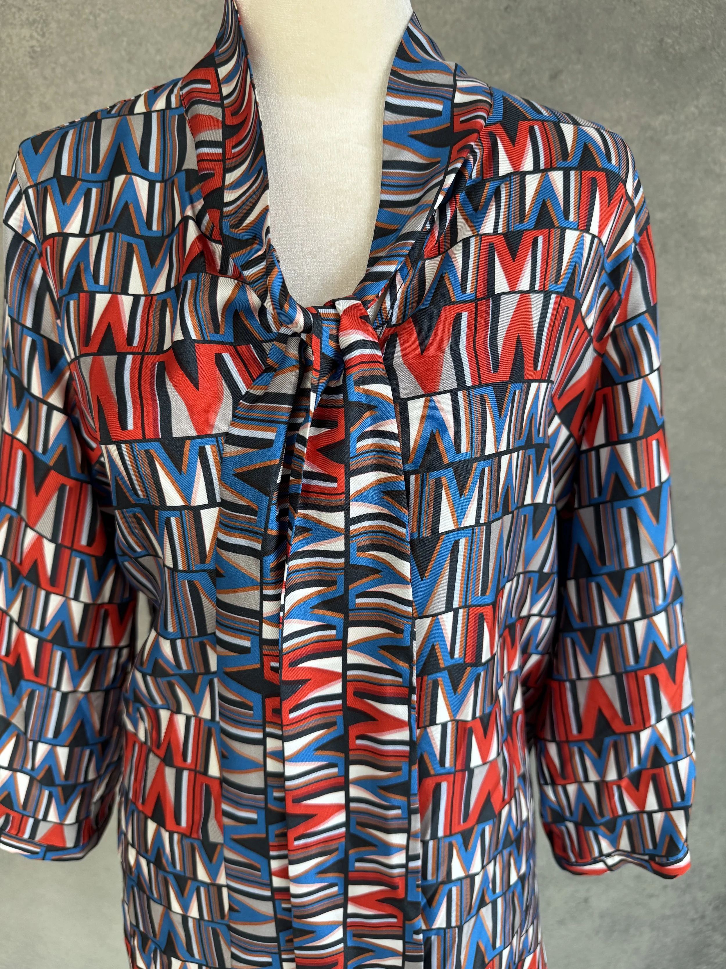 Close-up of the blouse collar featuring the signature pussy-bow tie detail.