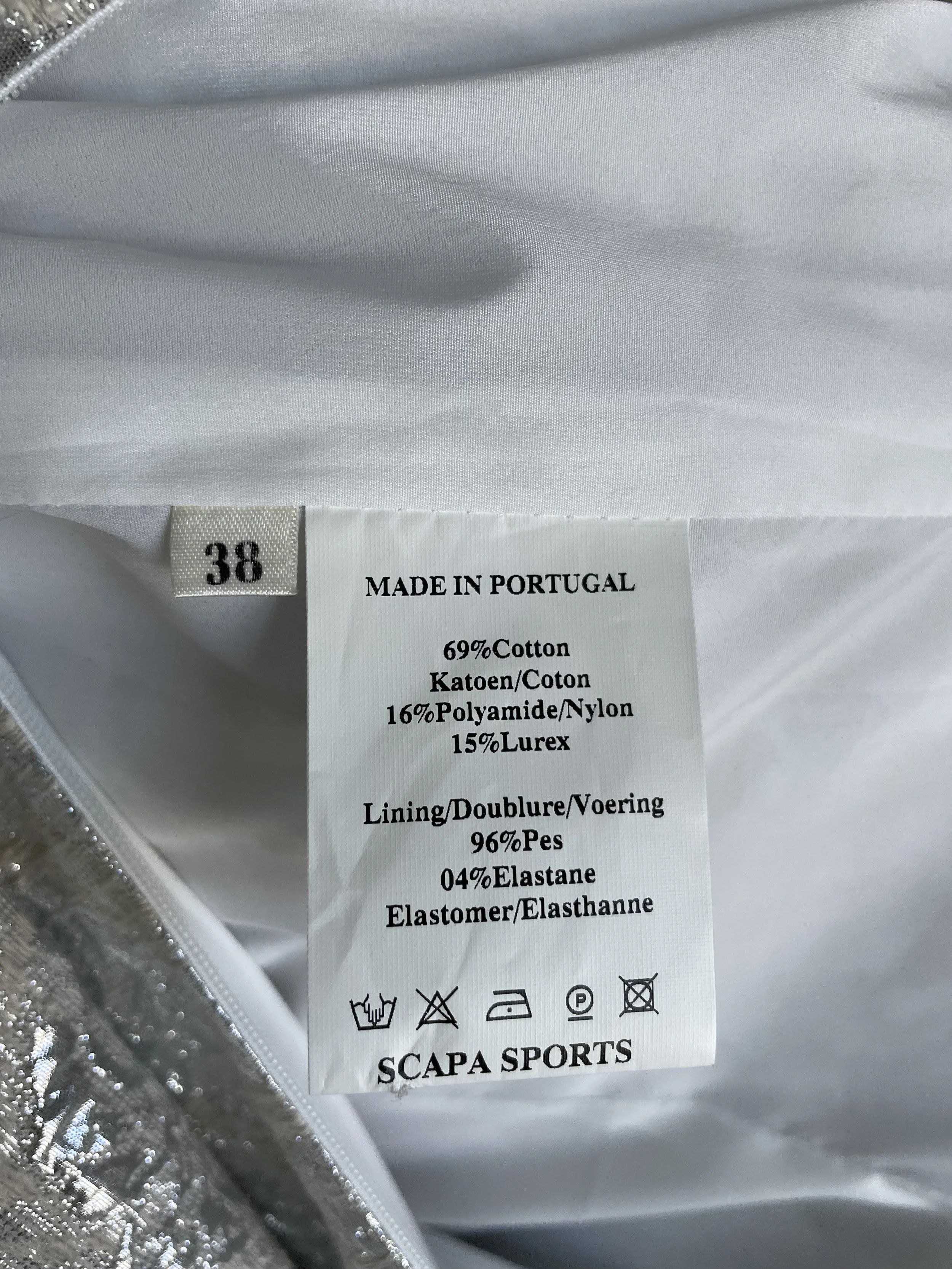 Interior care label showing 'Made in Portugal', size 38, and fabric composition of cotton, polyamide, and lurex.