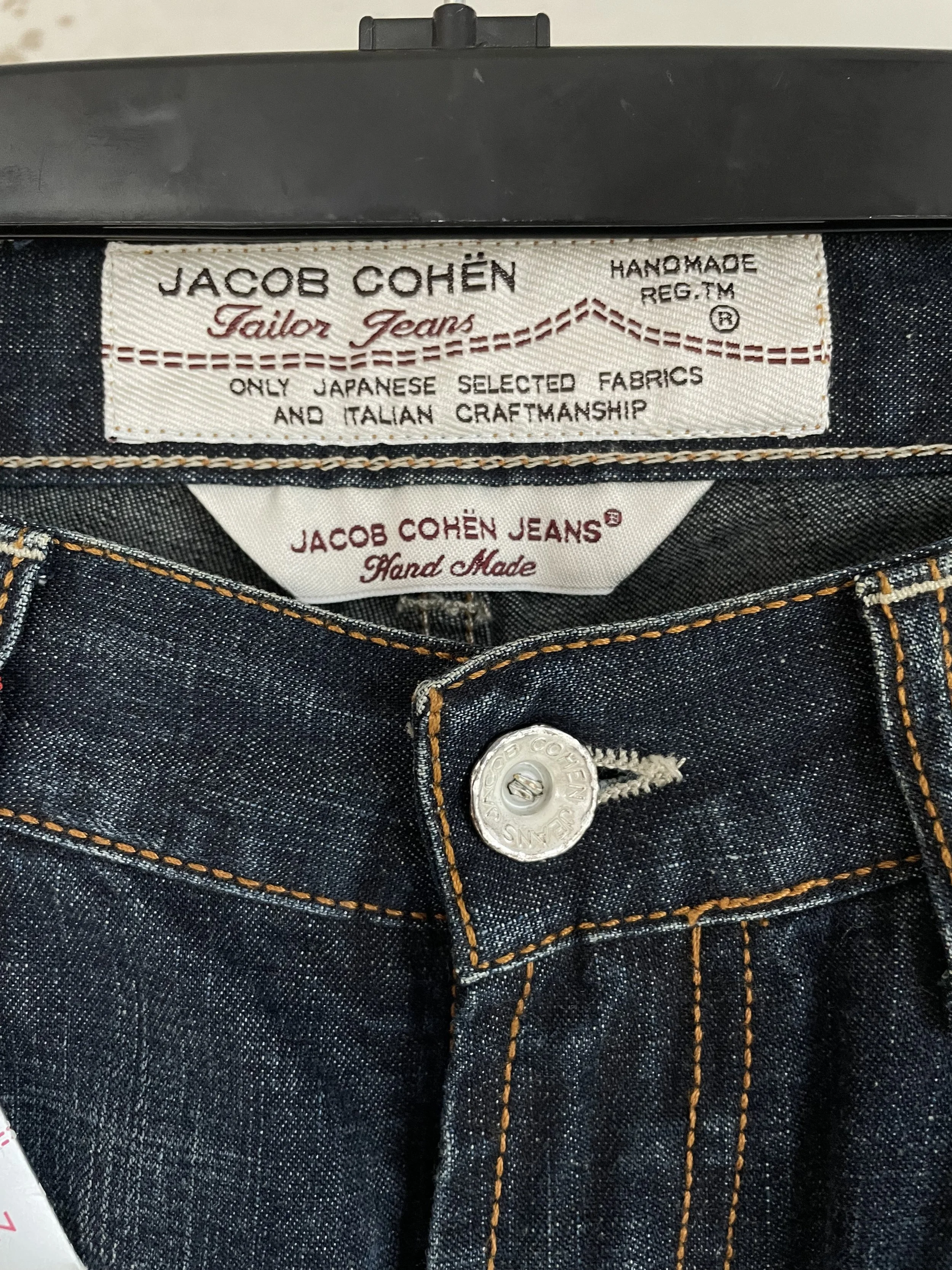 Detail shot of the Jacob Cohën waist button and pocket detailing on a mannequin.