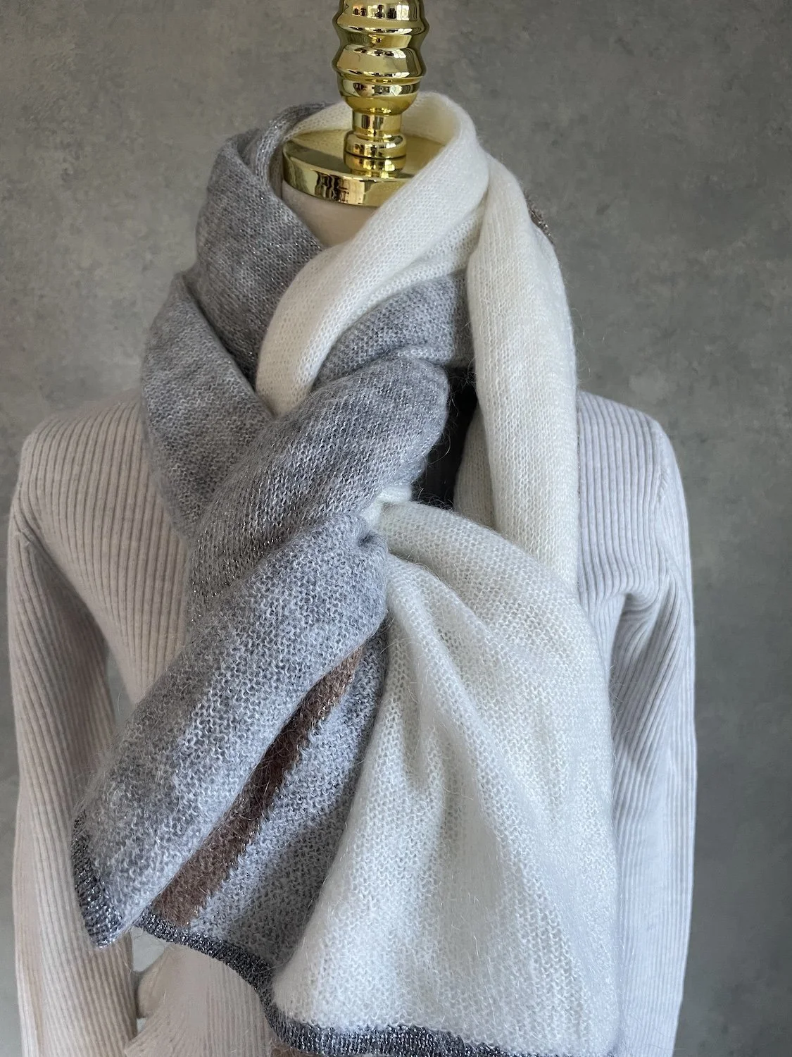 Close-up of the grey and cream sections wrapped around the neck, highlighting the soft knit texture.