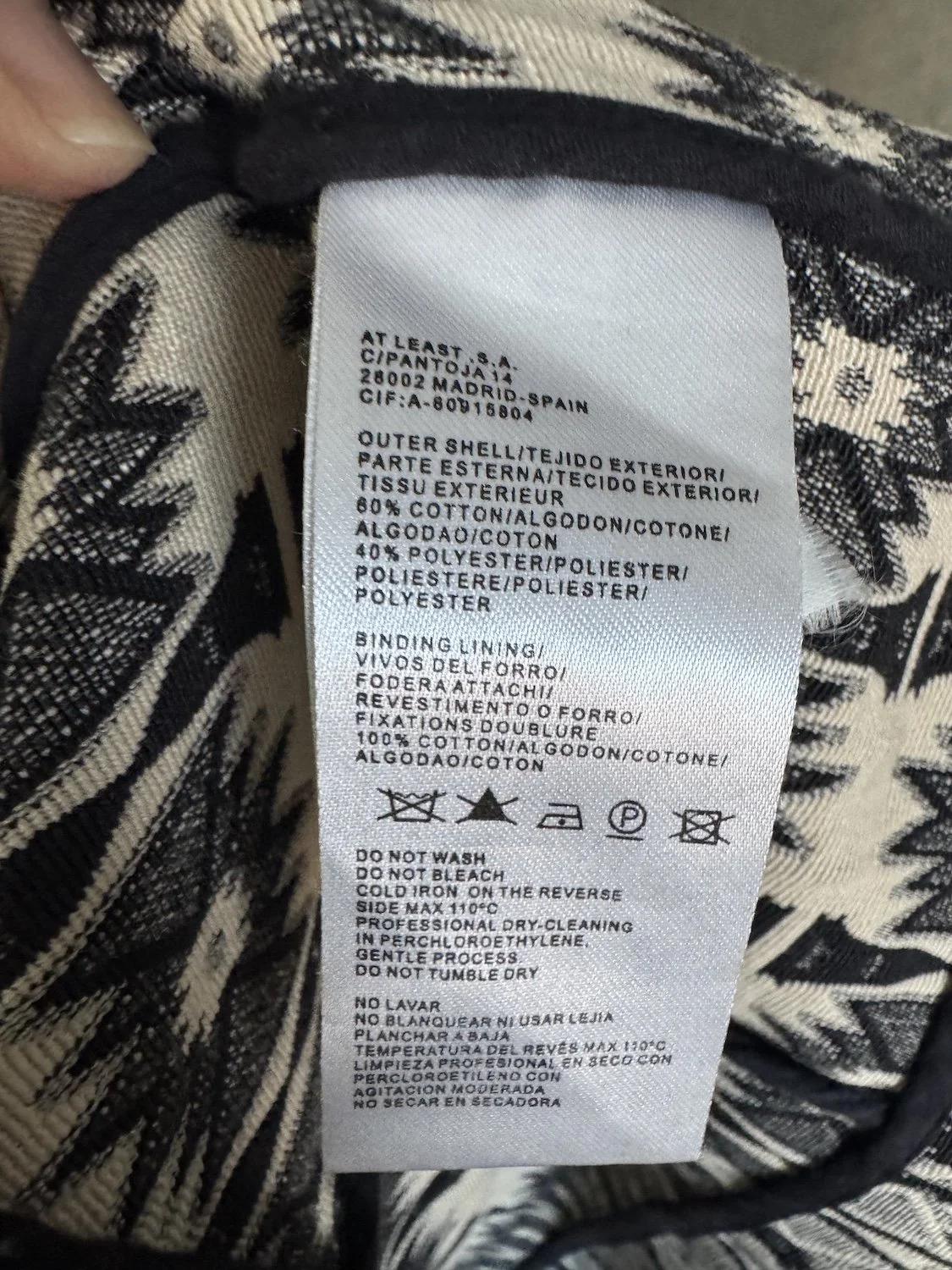 Close-up of care label showing 60% cotton 40% polyester composition and inner binding details