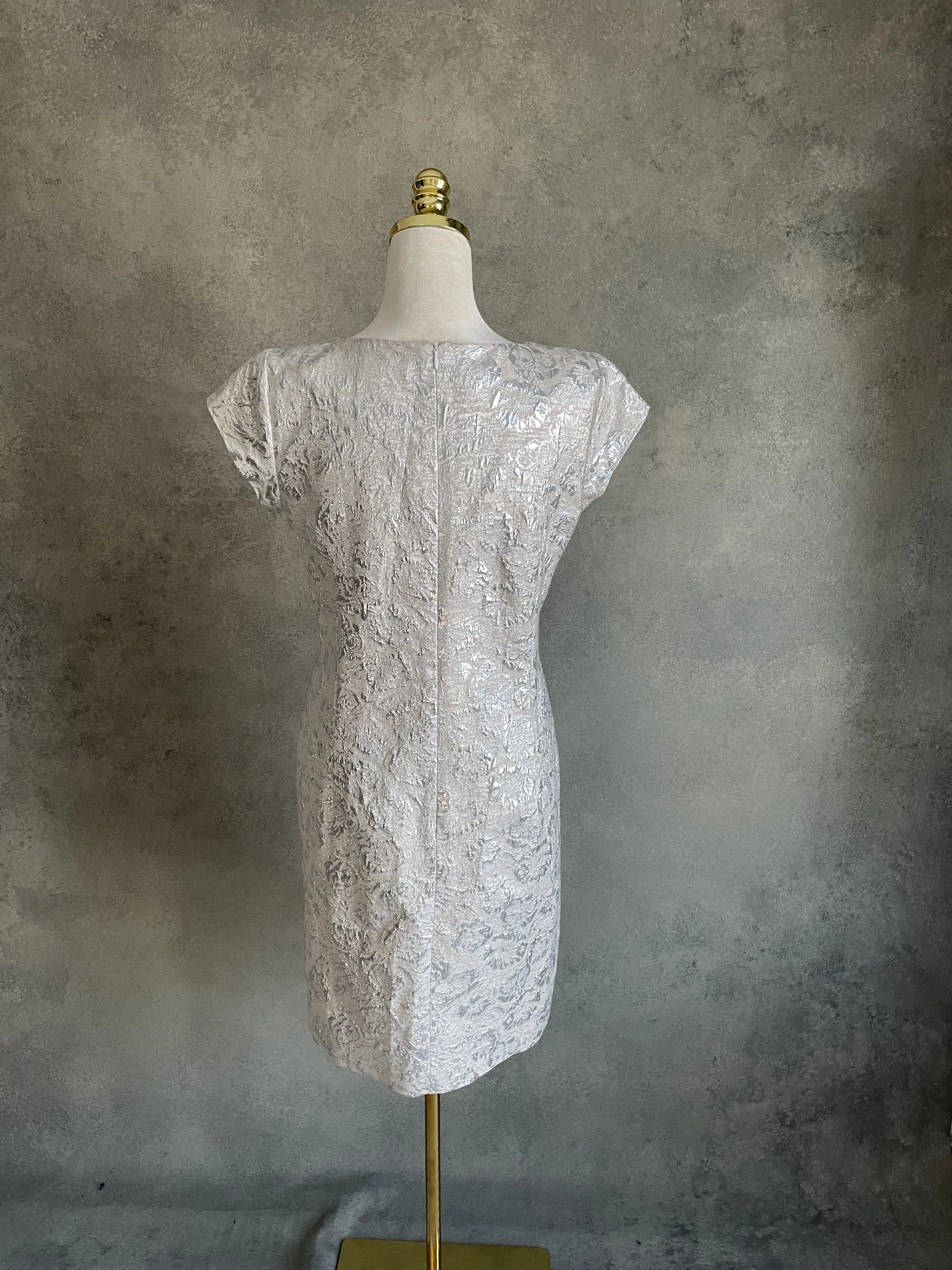 Back view of the structured silver Scapa dress, highlighting the tailored silhouette and hidden zipper.
