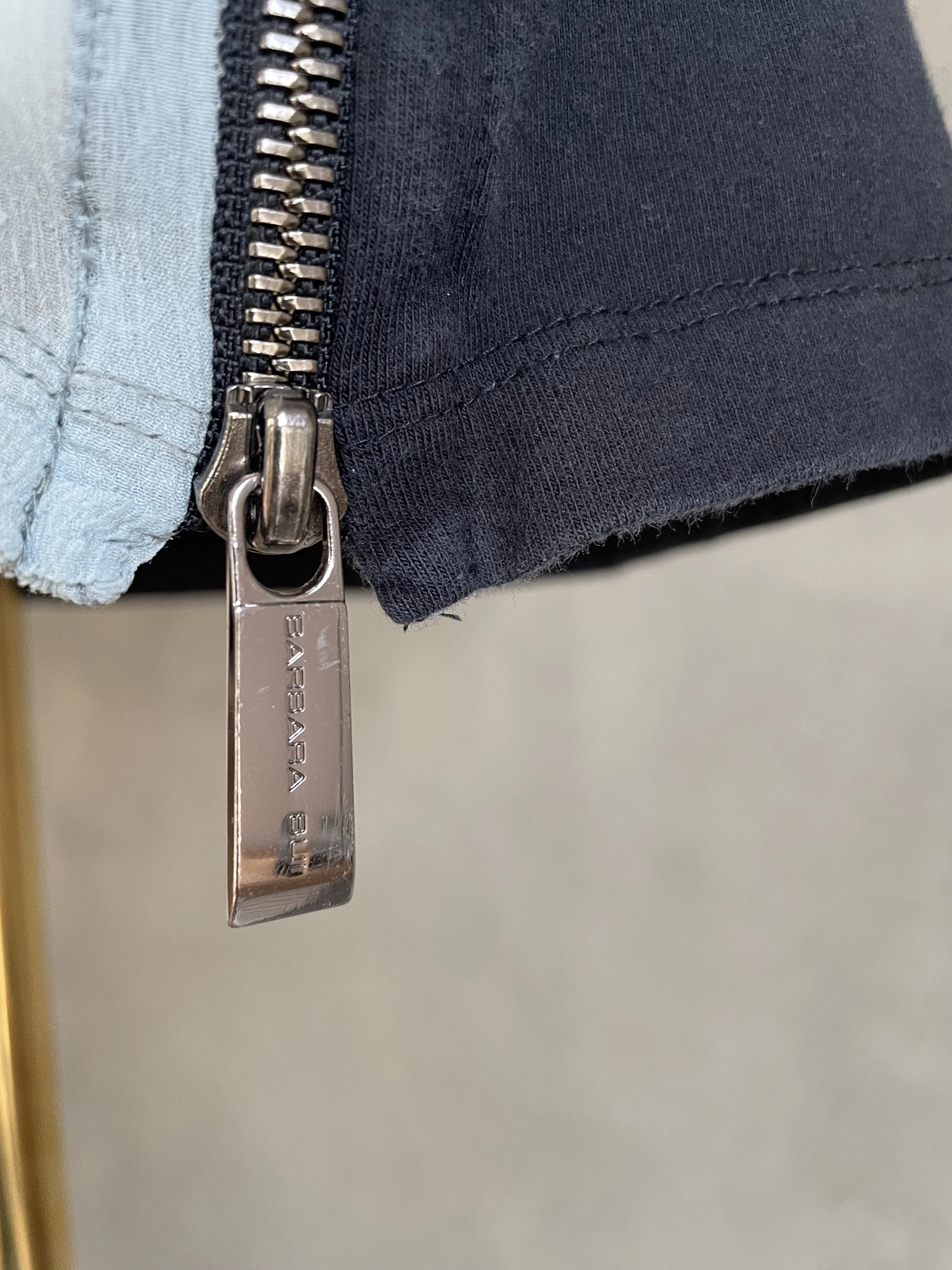 Close-up of the silver branded zipper pull with "BARBARA BUI" engraving.