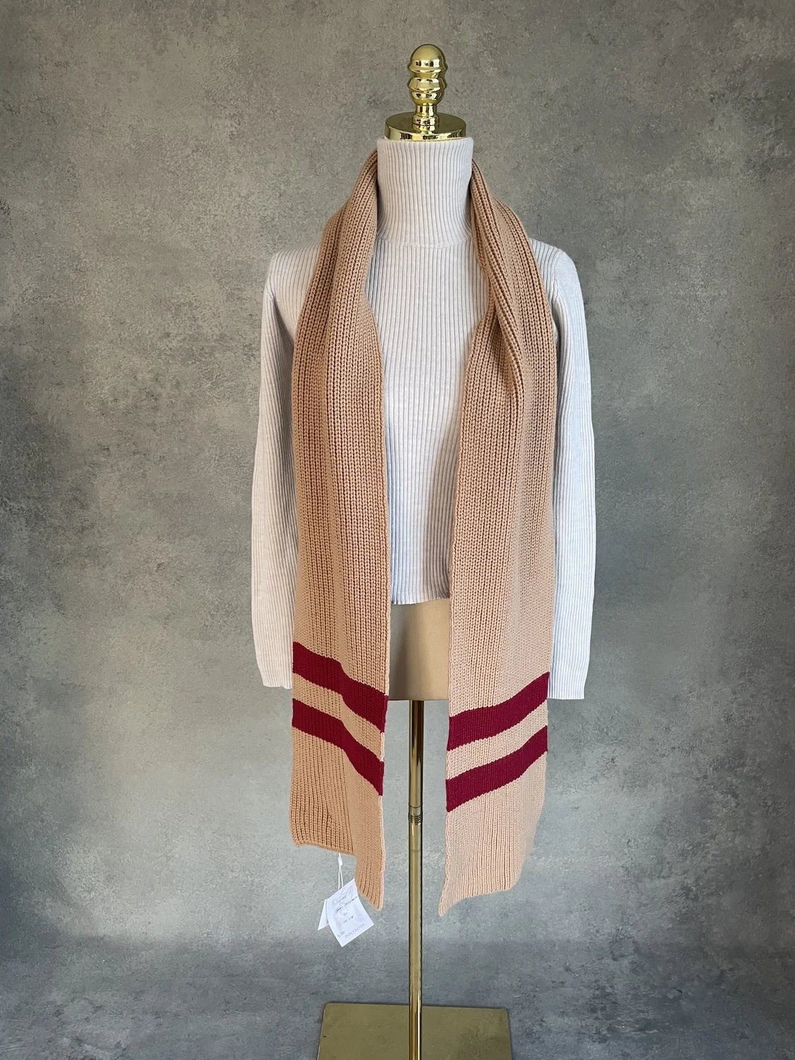 Close-up of the loosely draped Baum und Pferdegarten soft merino wool blend scarf in camel and bordeaux.