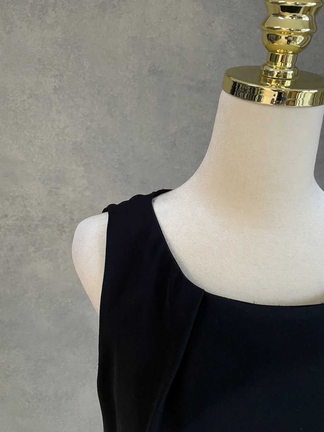 Close-up view of the neckline and shoulder strap of the black bodice, showing the elegant drape.